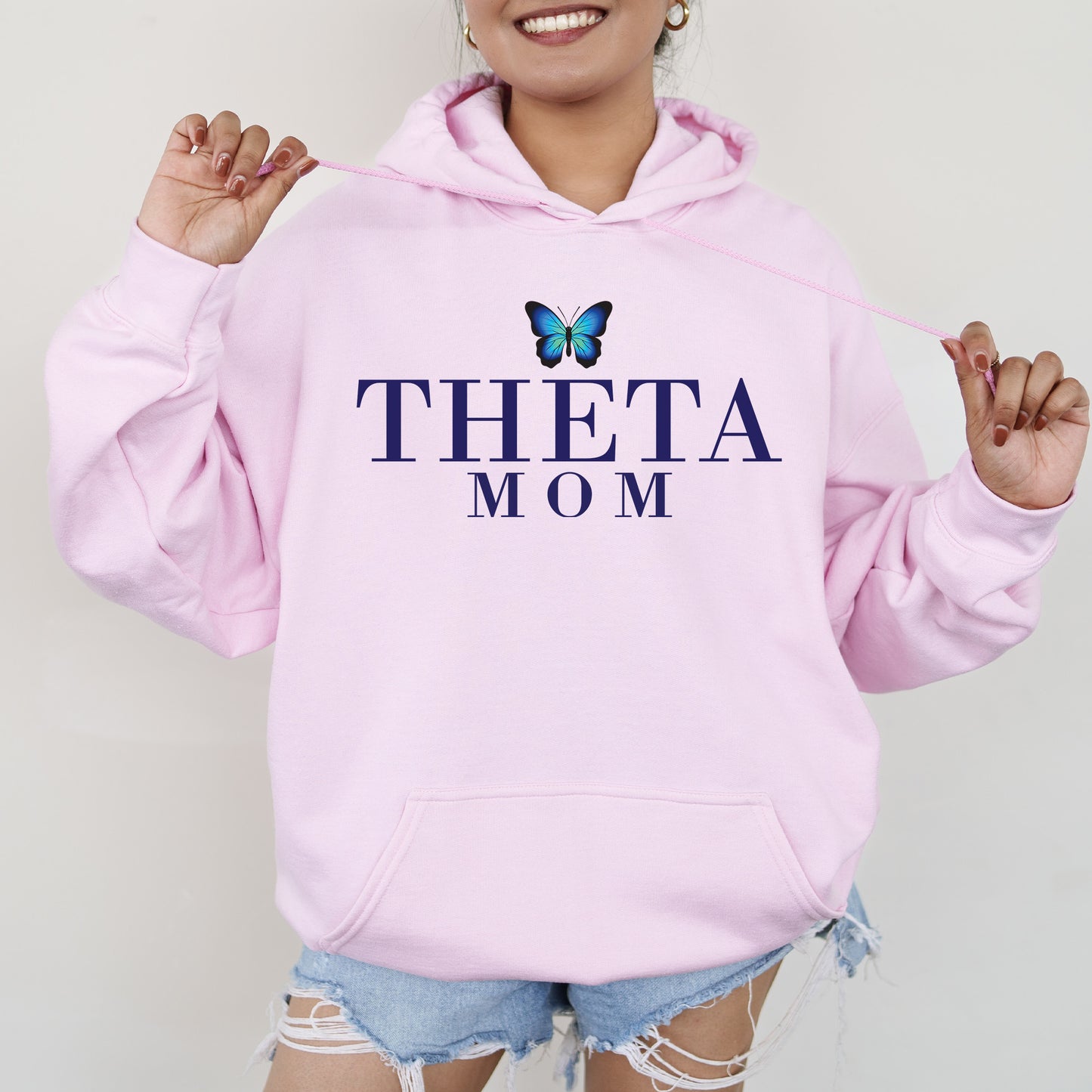 a woman wearing a pink sweatshirt with a butterfly on it