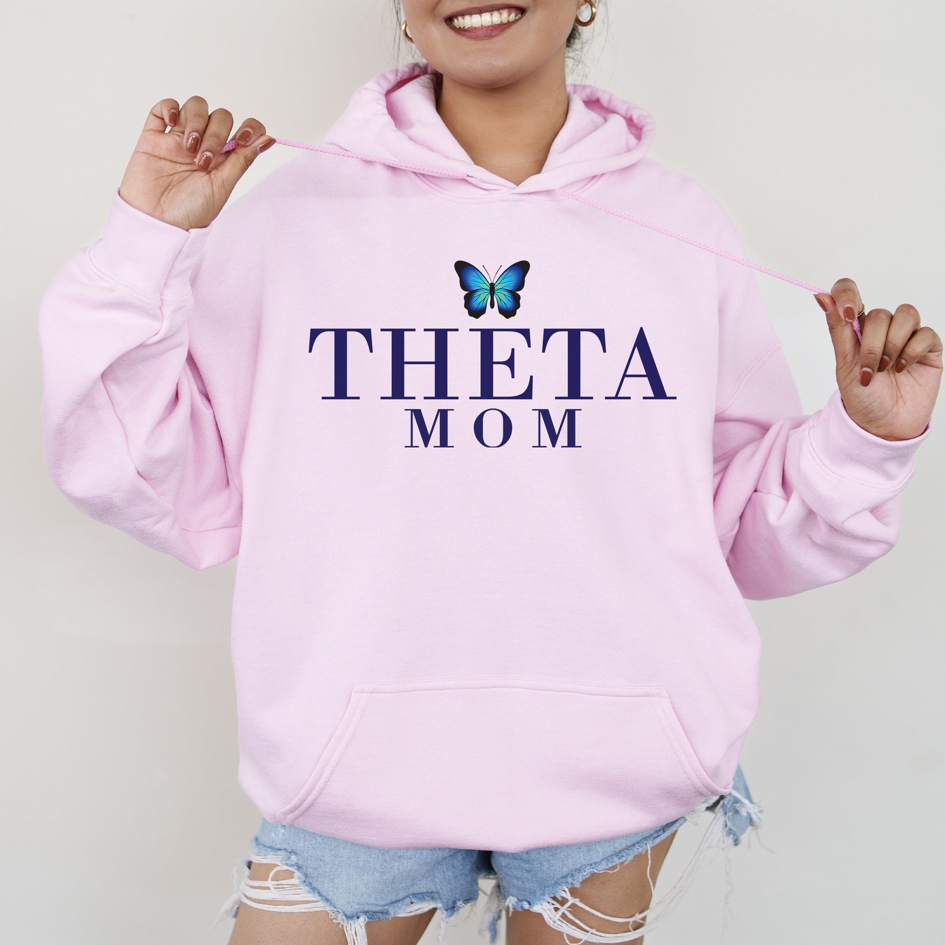 a woman wearing a pink sweatshirt with a butterfly on it