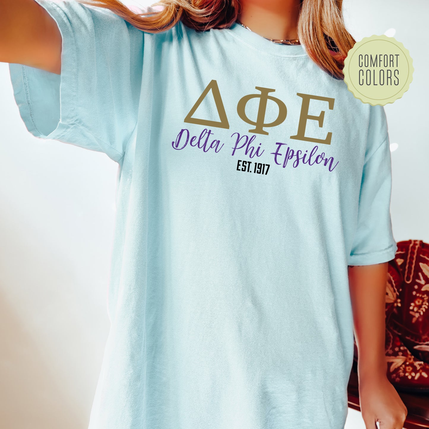 a woman wearing a light blue delta phi phi shirt