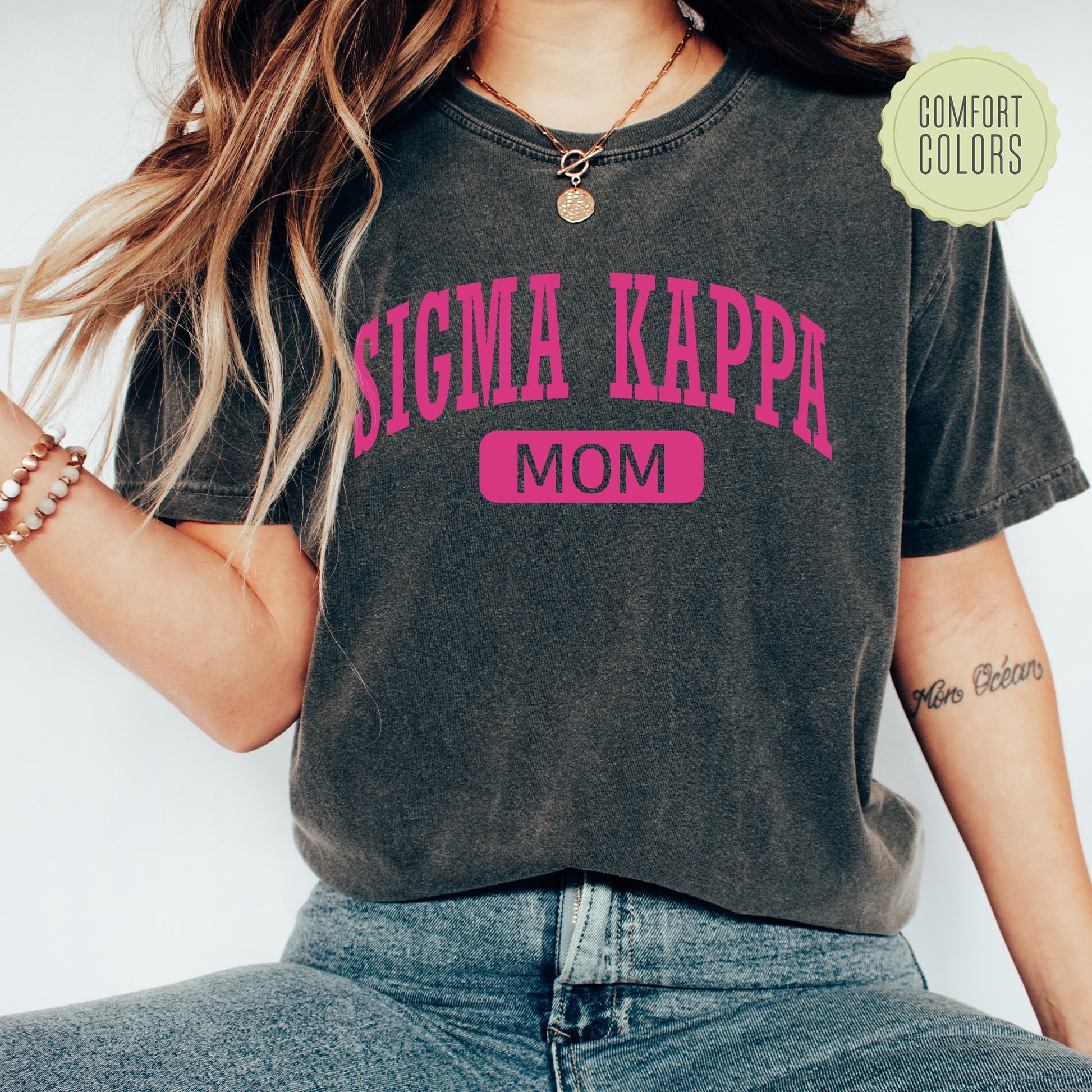a woman wearing a shirt that says stigmaa kappa mom
