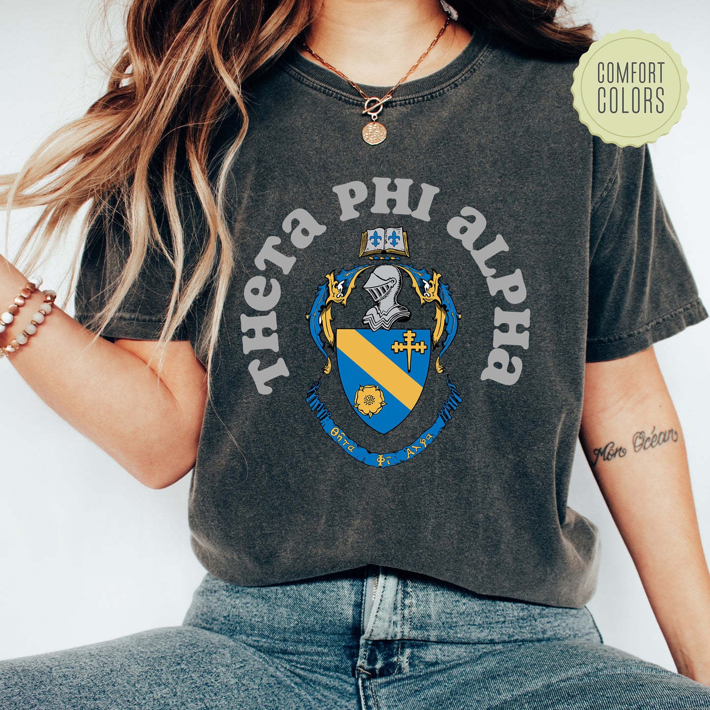a woman wearing a t - shirt with a coat of arms on it