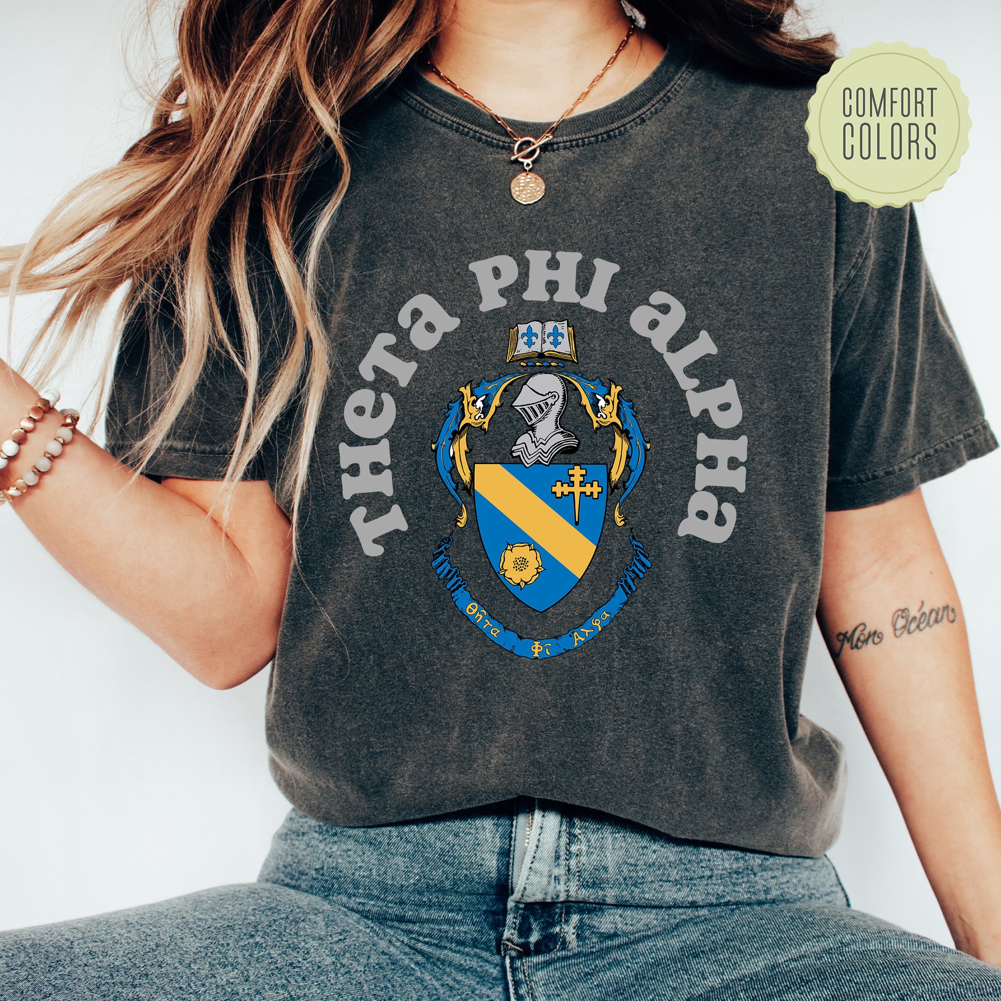 a woman wearing a t - shirt with a coat of arms on it