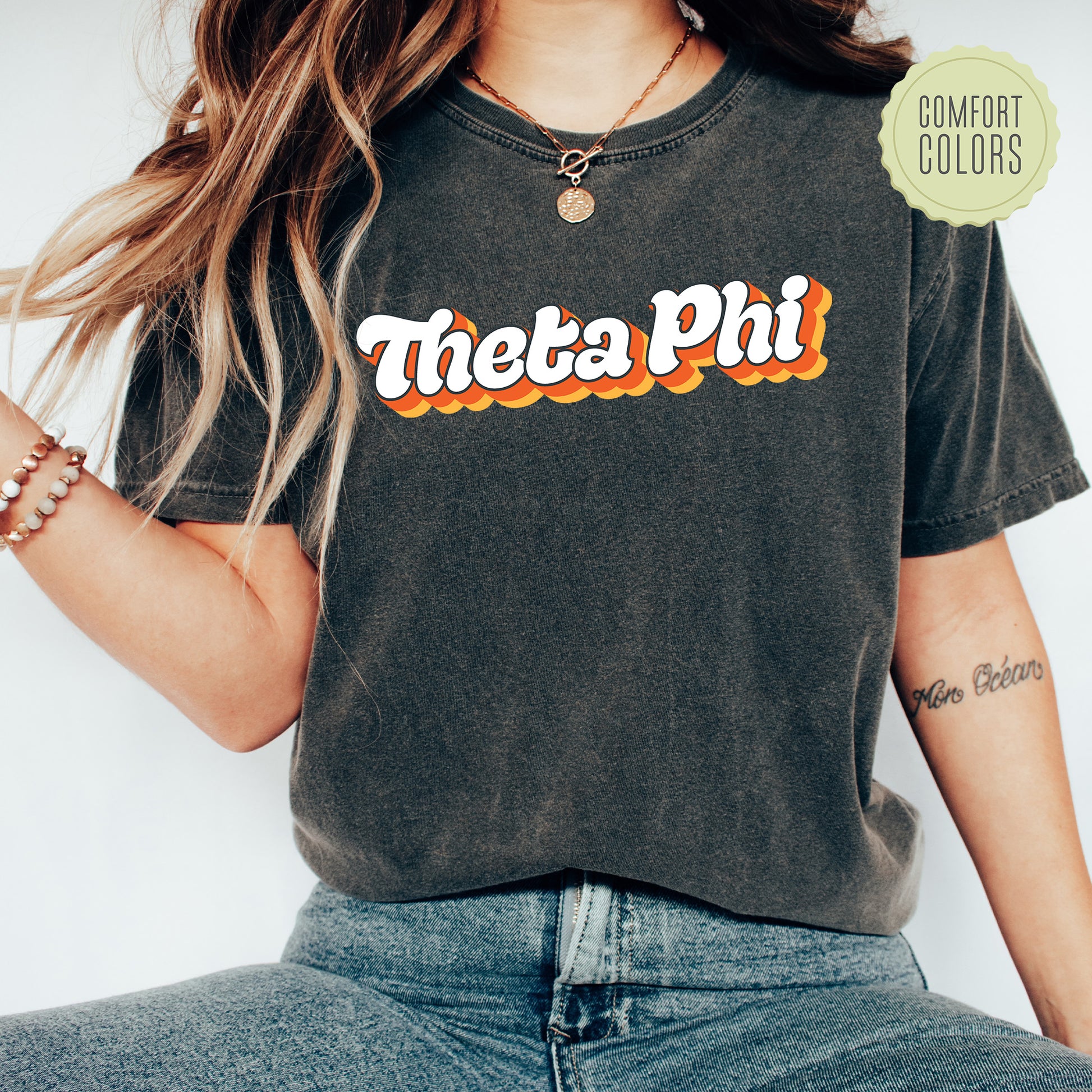 a woman wearing a black shirt with the word thea phi on it