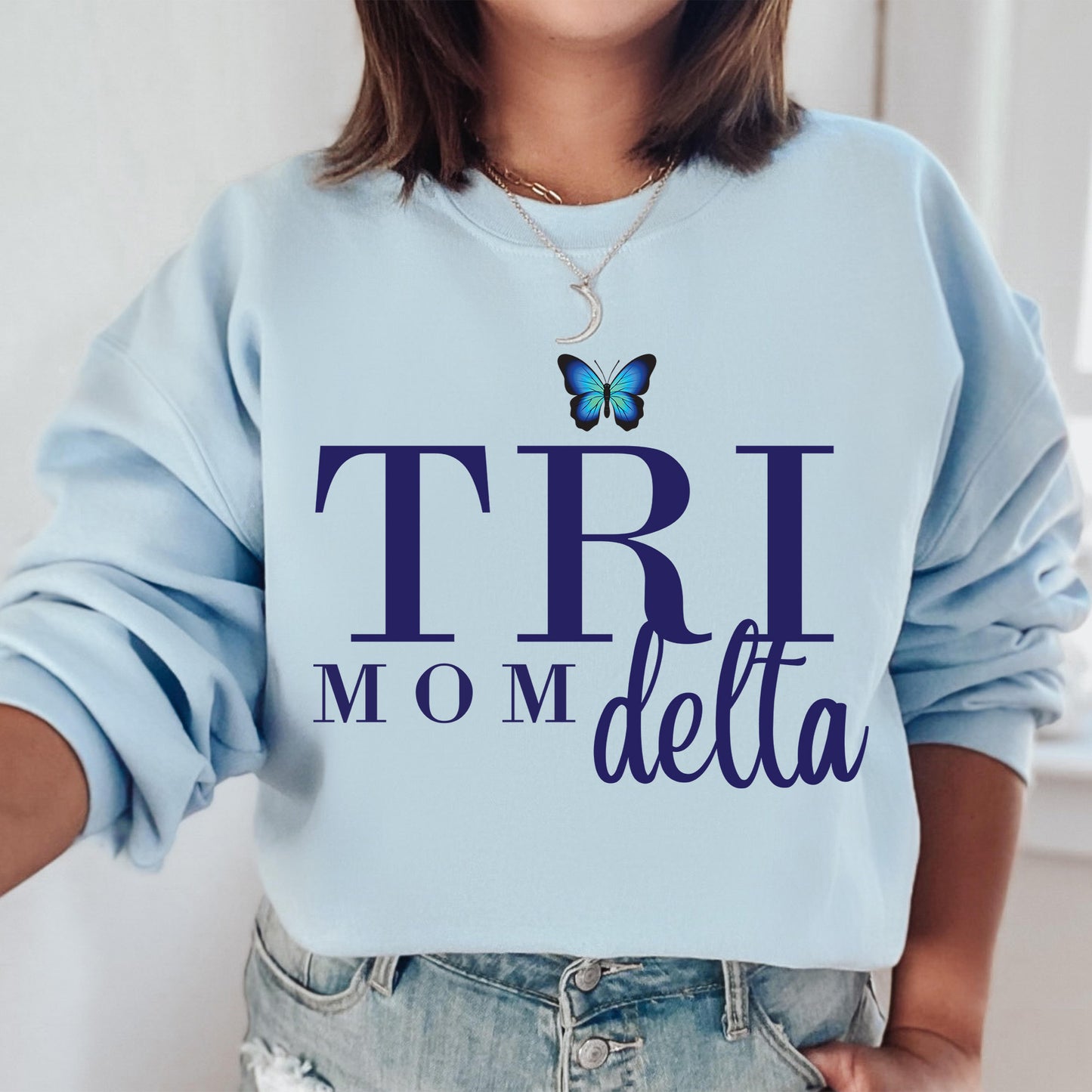 a woman wearing a blue sweatshirt with a butterfly on it