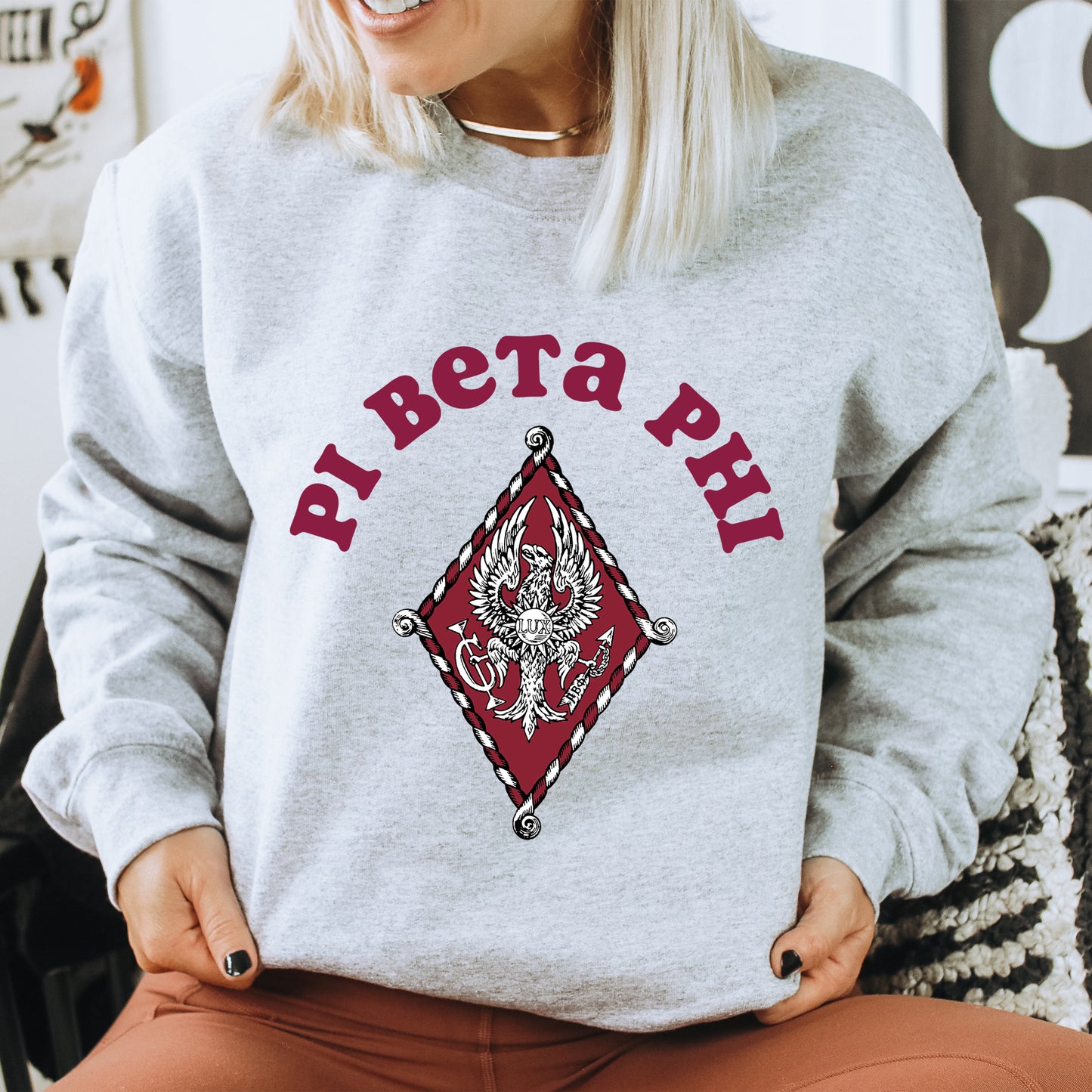 a woman sitting on a chair wearing a sweatshirt