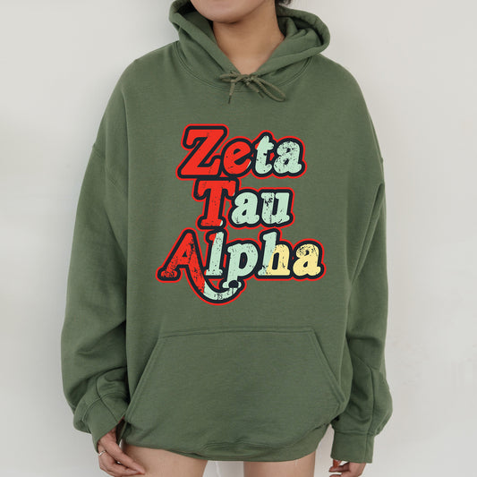 a woman wearing a green hoodie that says zeta tau alpha