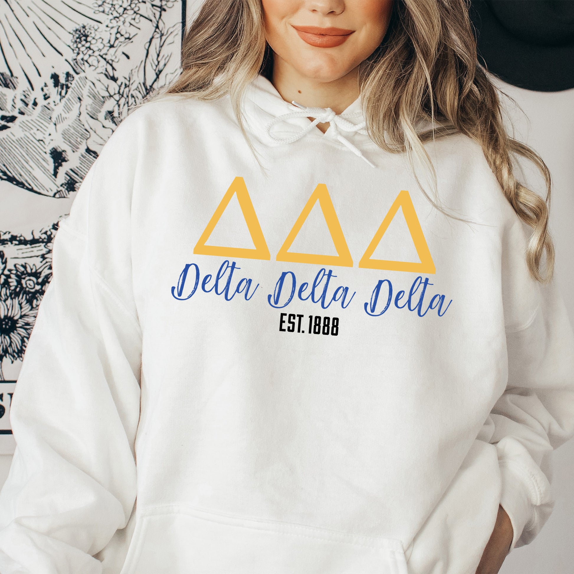 a woman wearing a white delta delta hoodie