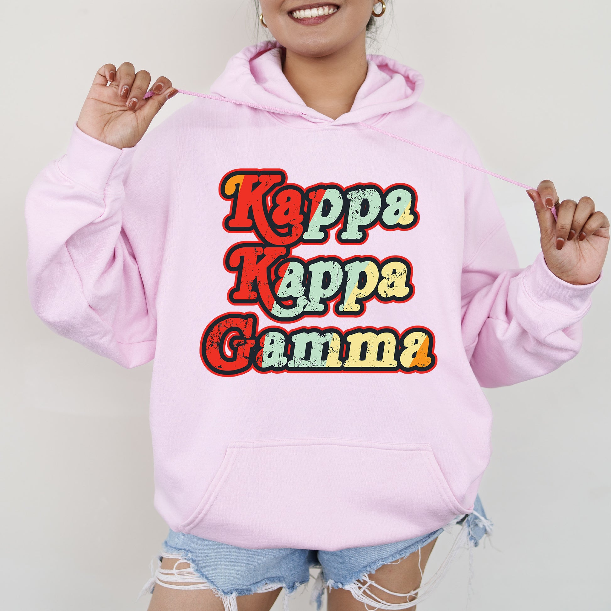 a woman wearing a pink hoodie with the words kapa kapa gumma