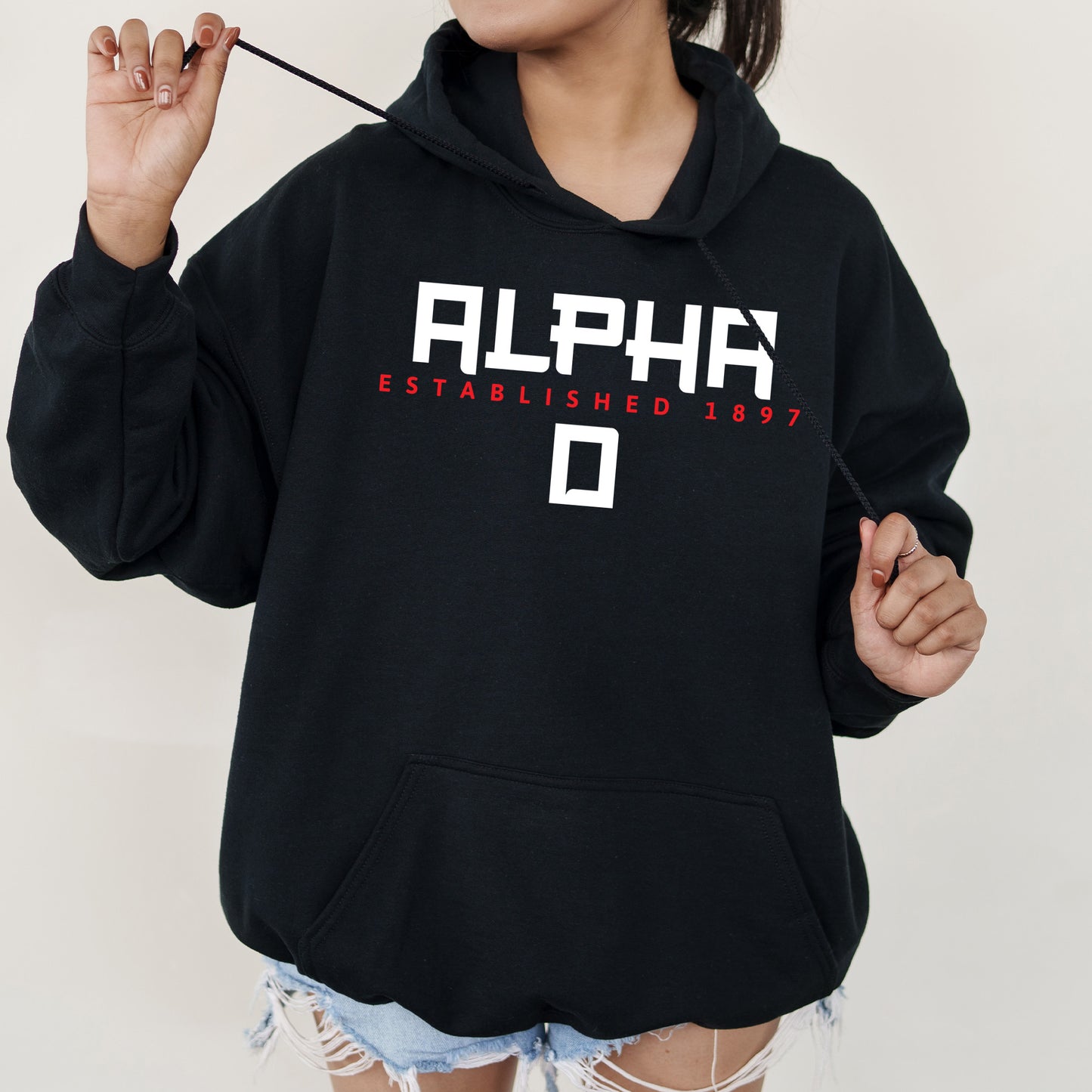 a girl in a black hoodie is holding an umbrella