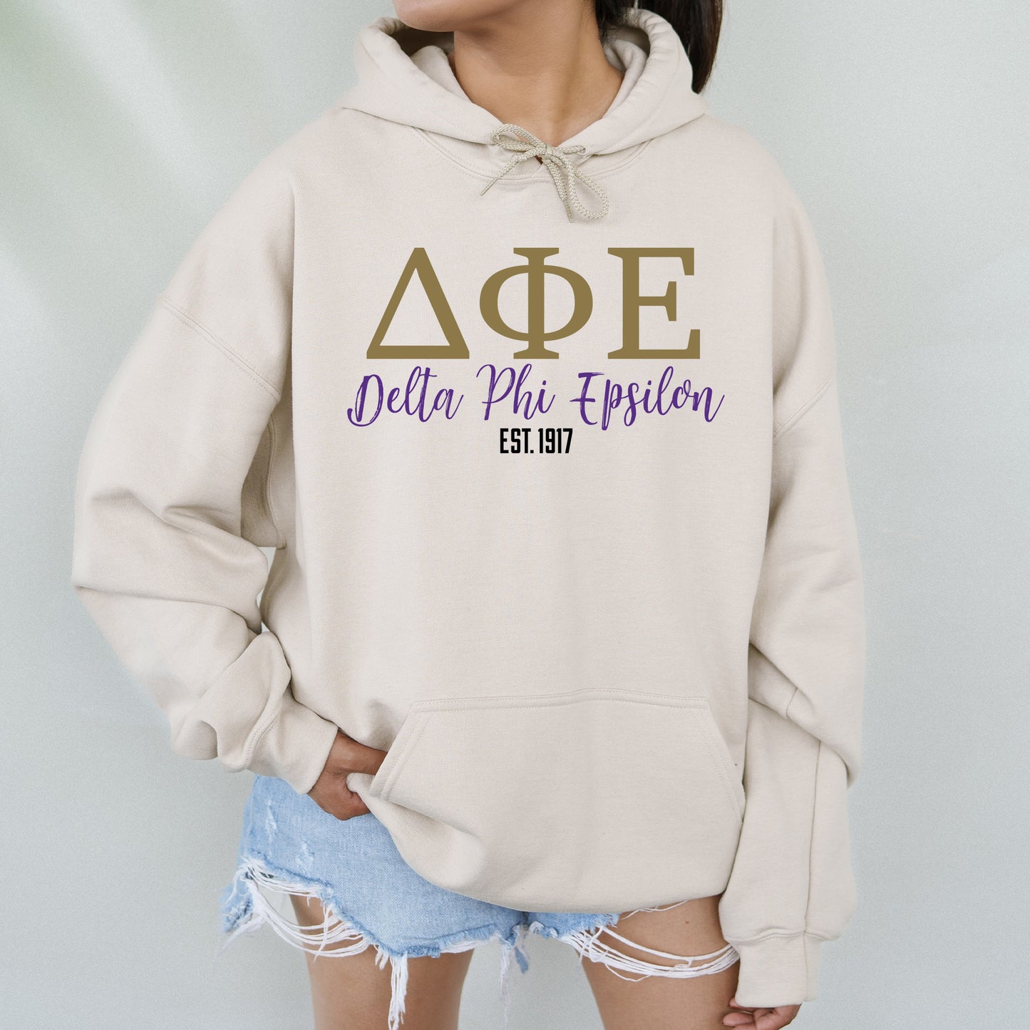 a woman wearing a hoodie that says delta phi phi