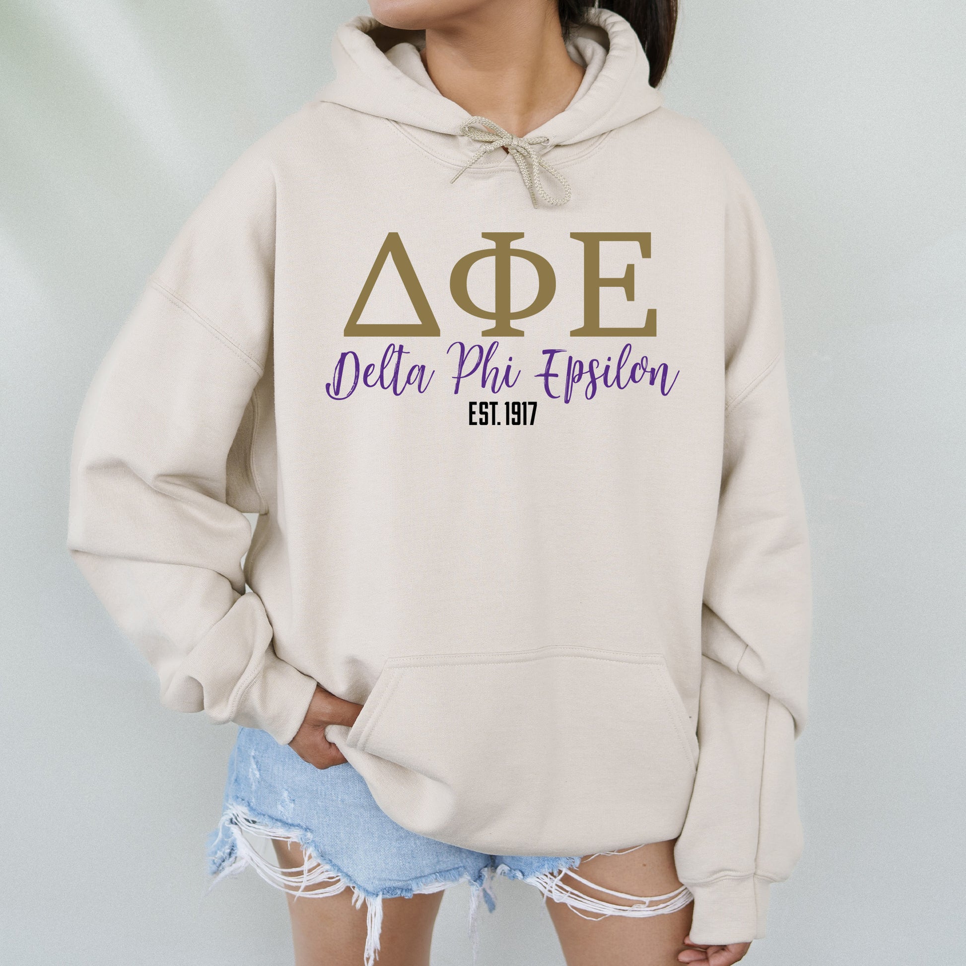 a woman wearing a hoodie that says delta phi phi
