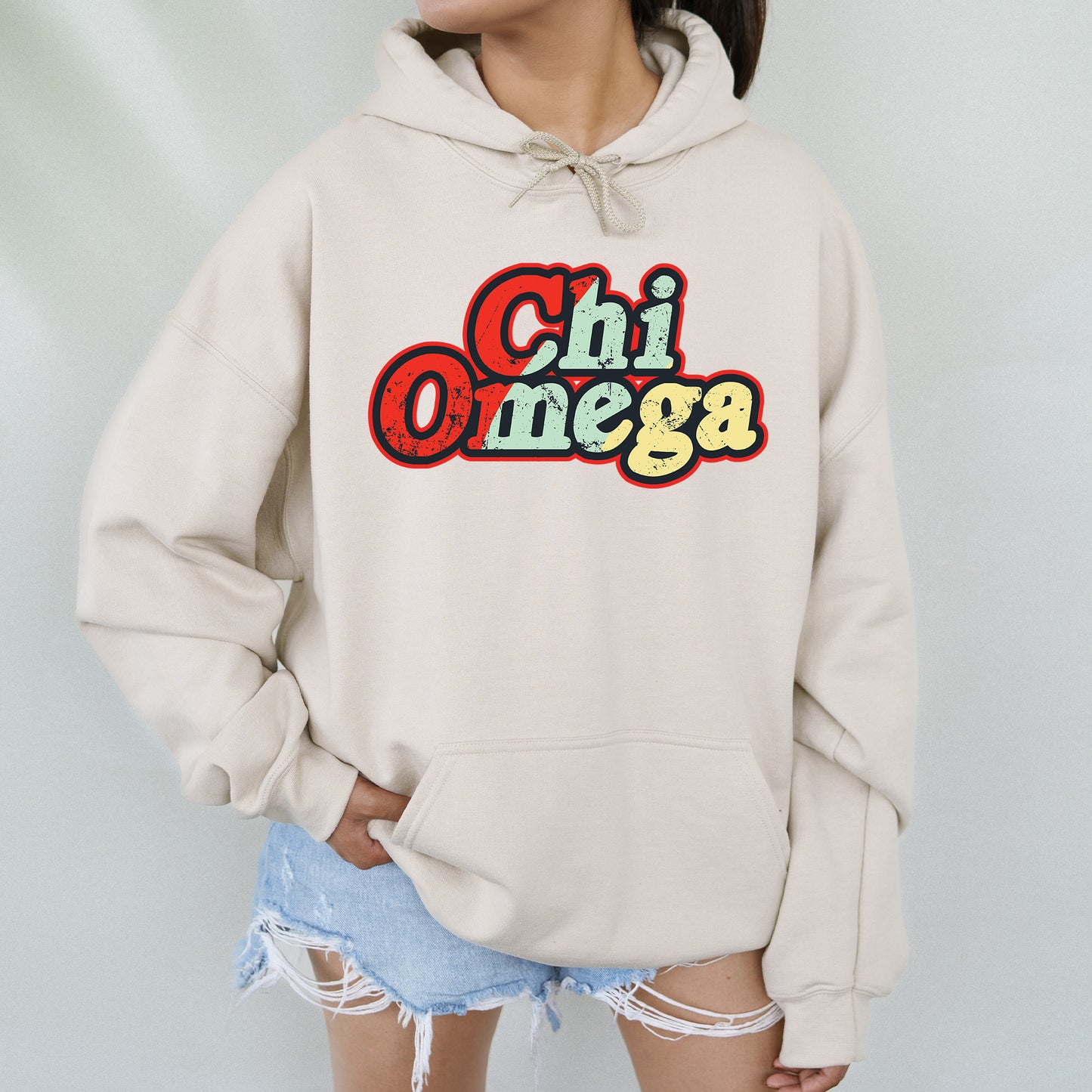 a woman wearing a hoodie with the word chi omega on it