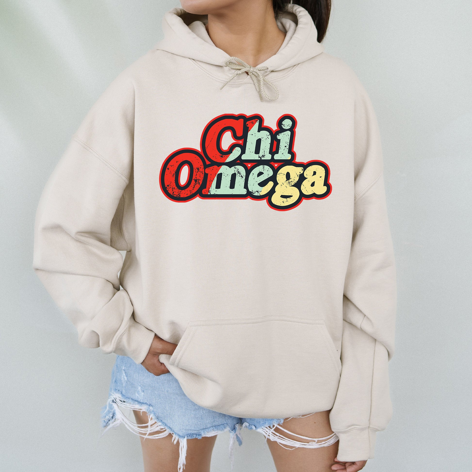 a woman wearing a hoodie with the word chi omega on it