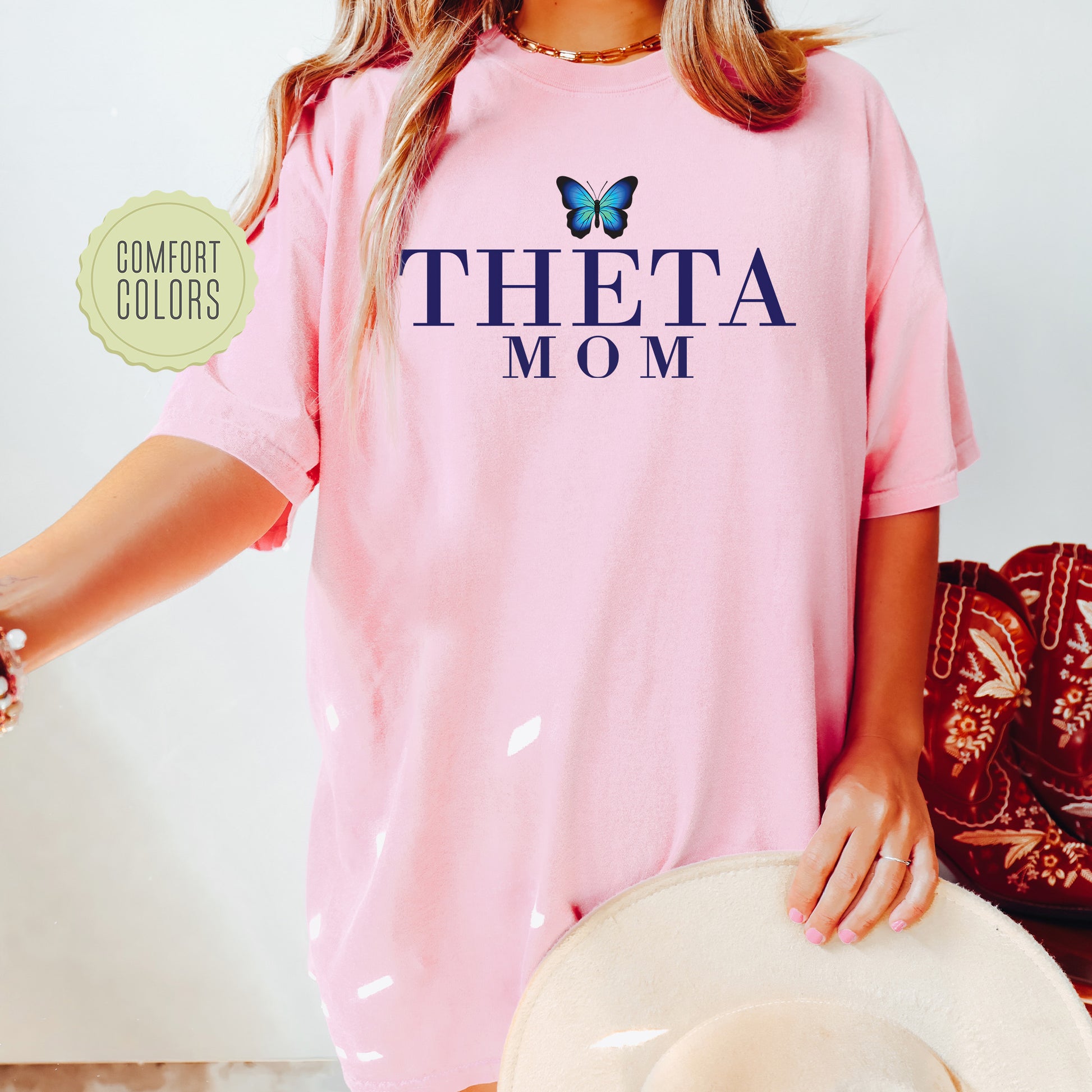 a woman wearing a pink shirt with a butterfly on it
