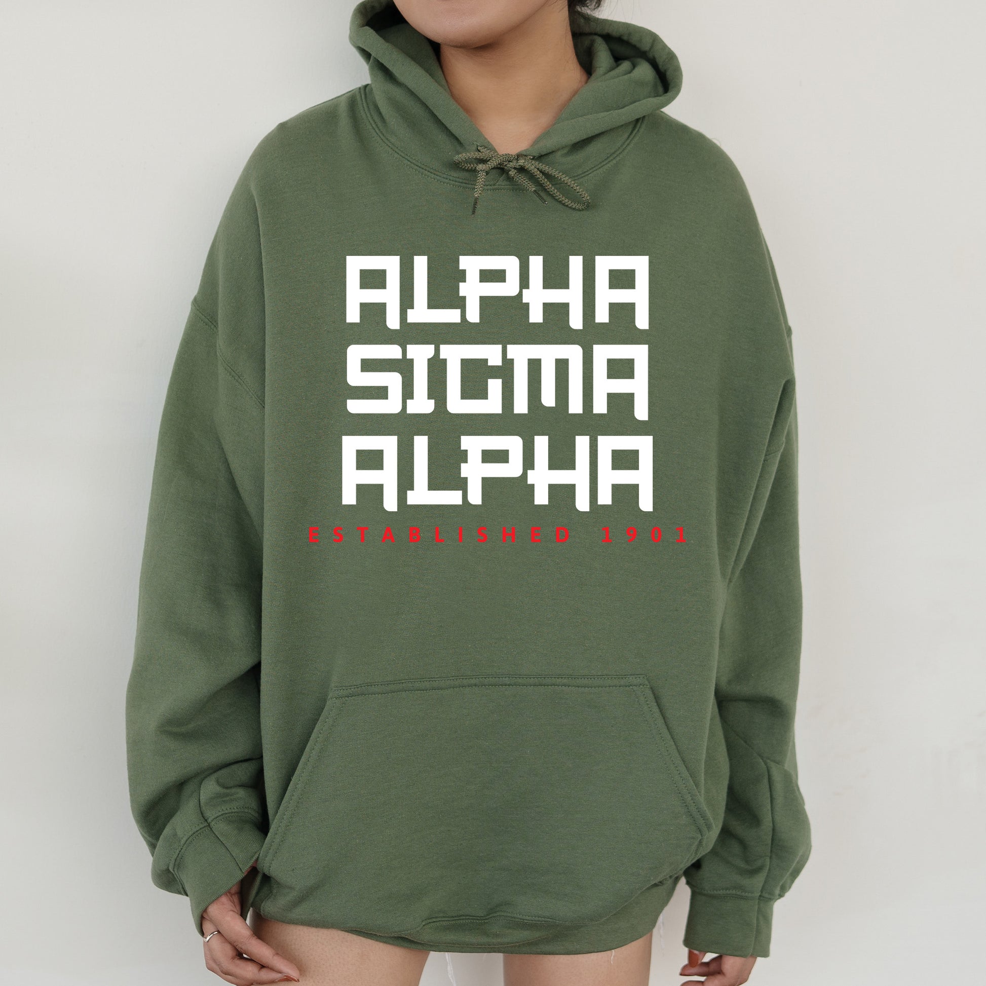 a person wearing a green hoodie with the words alpama alpa on
