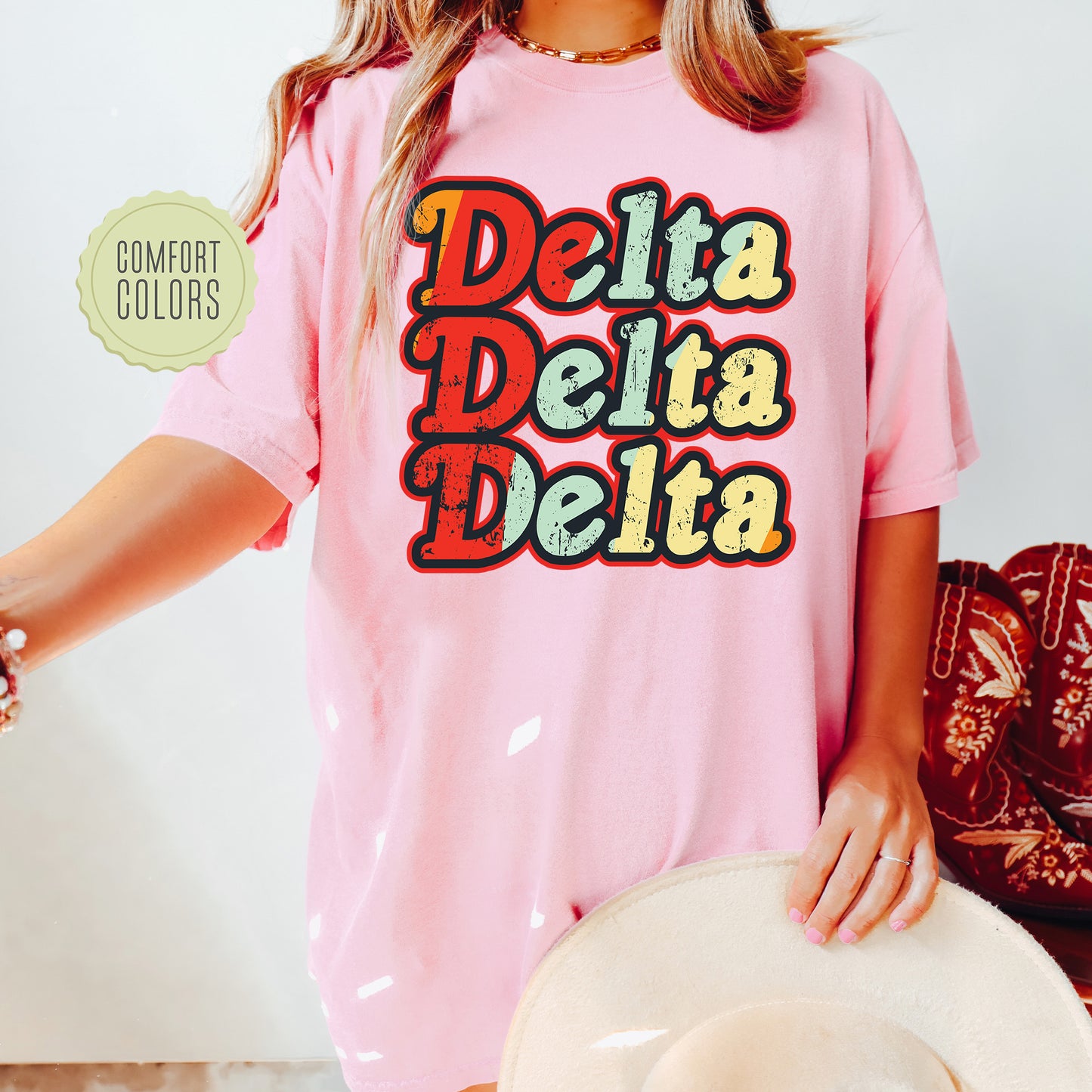 a woman wearing a pink shirt that says delta delta