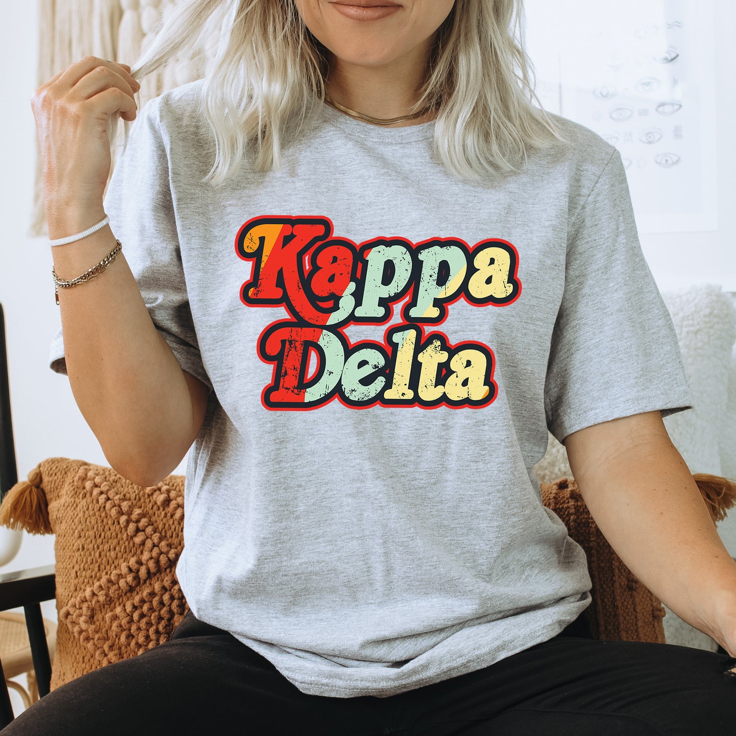 a woman sitting on a chair wearing a t - shirt that says kappa