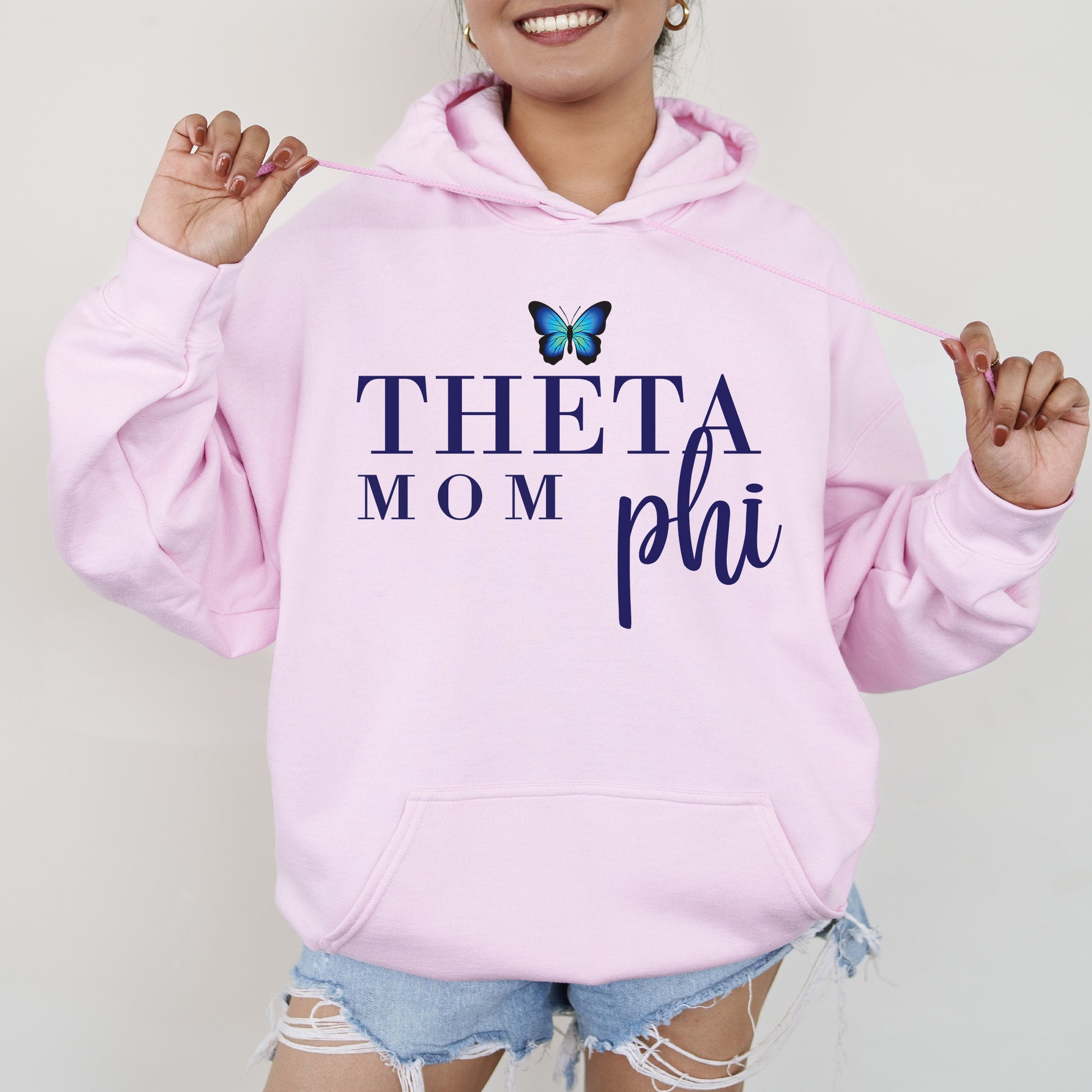 a woman in a pink hoodie with a butterfly on it