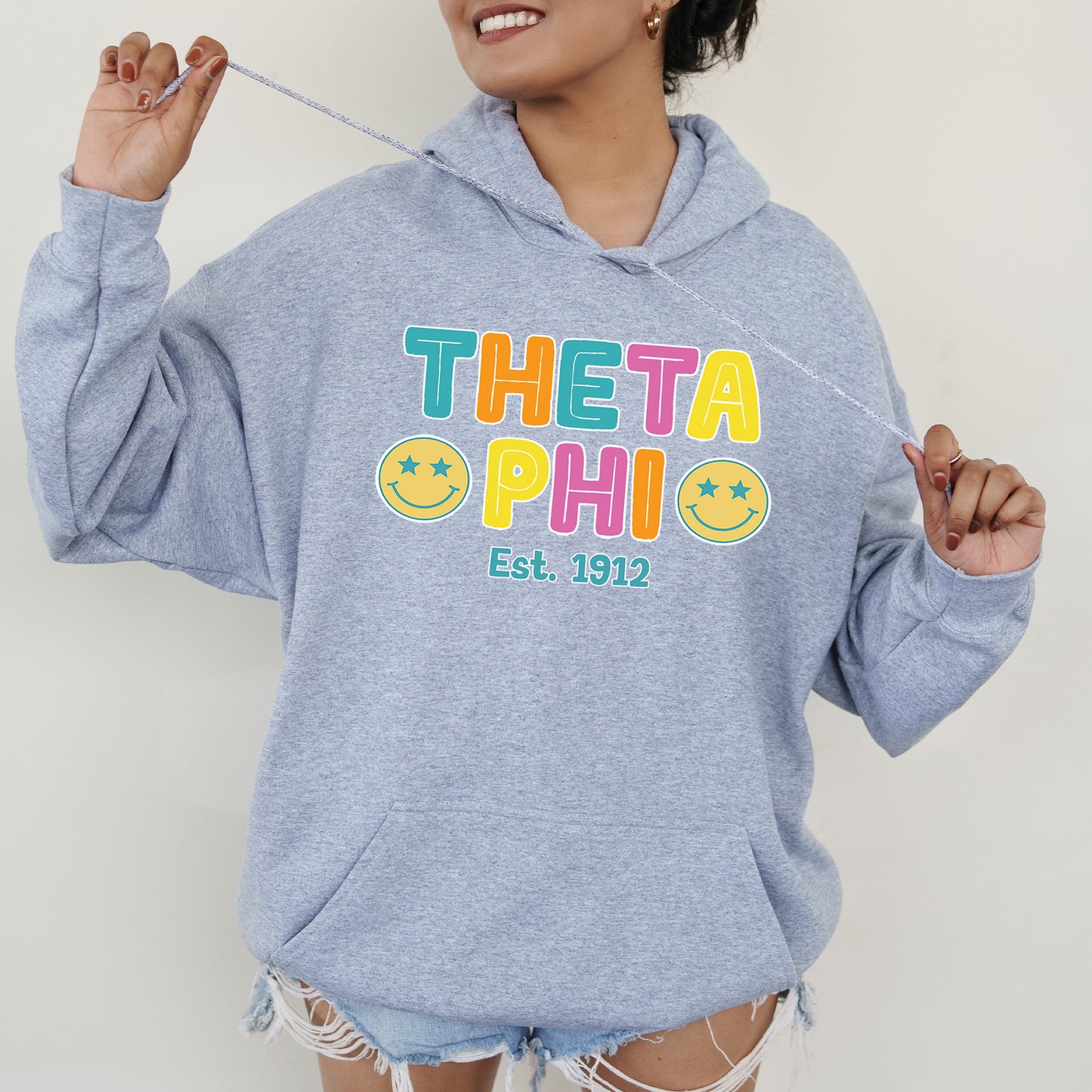 a woman in a blue hoodie is holding a toothbrush
