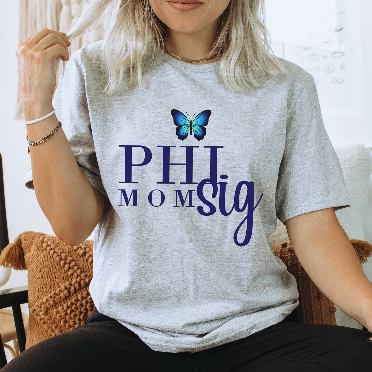 a woman sitting in a chair with a butterfly on her shirt