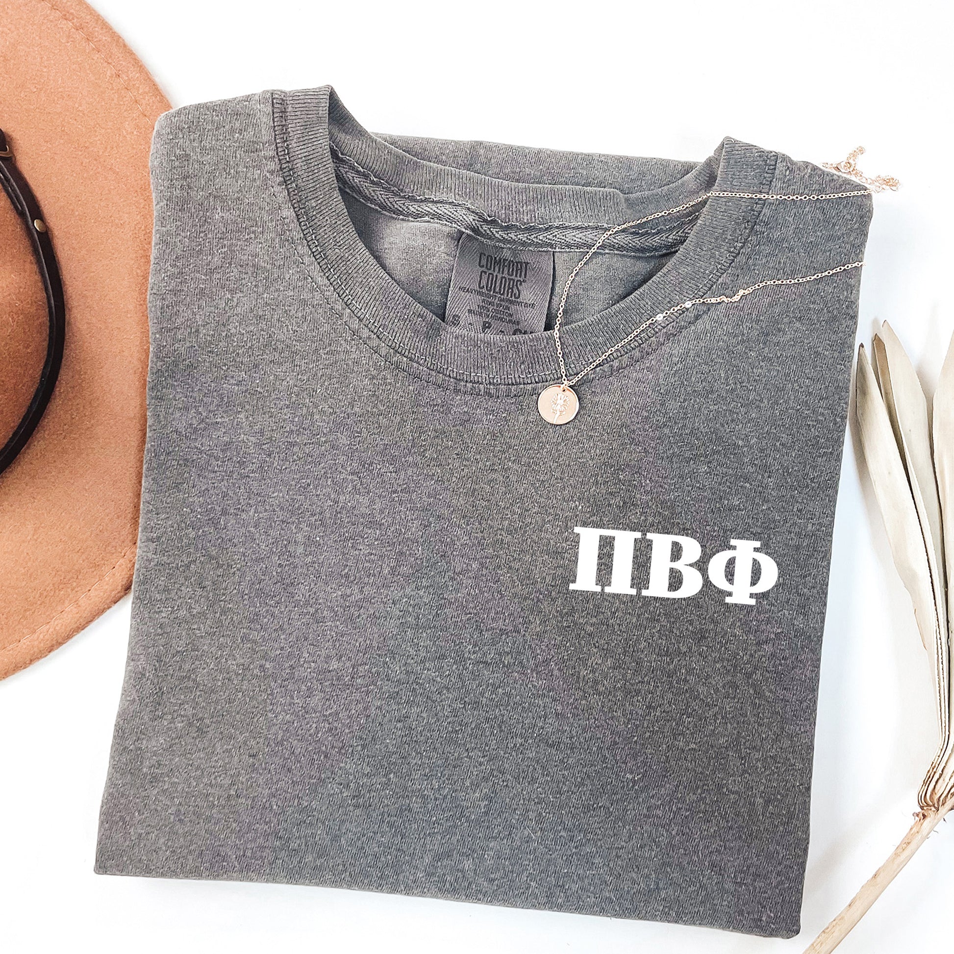 a hat, sunglasses, and t - shirt on a white surface