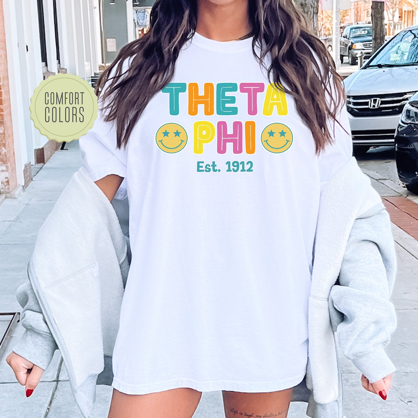 a woman wearing a white shirt with the words the tata phi on it