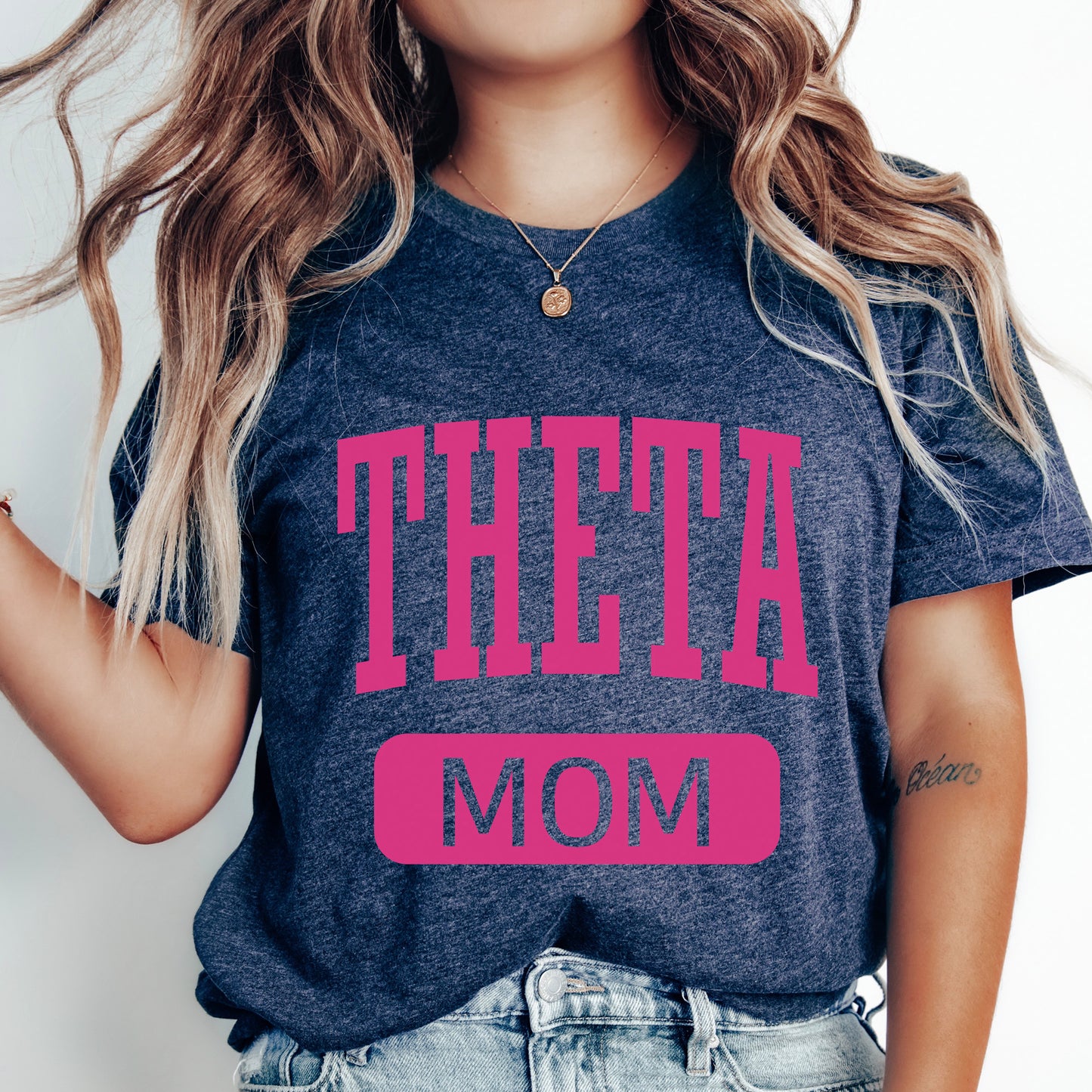 a woman wearing a t - shirt that says theeta mom