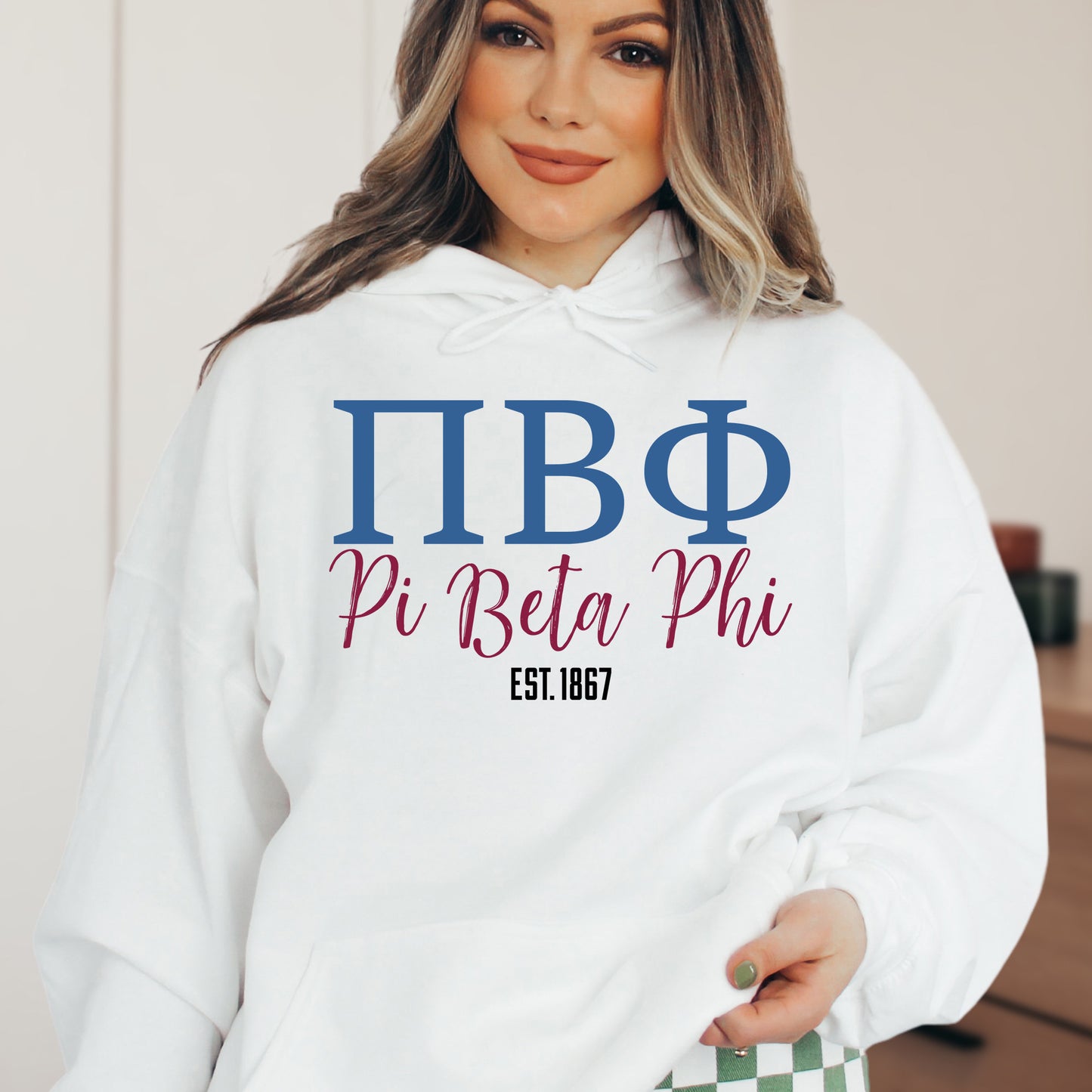 a woman wearing a white hoodie with greek letters