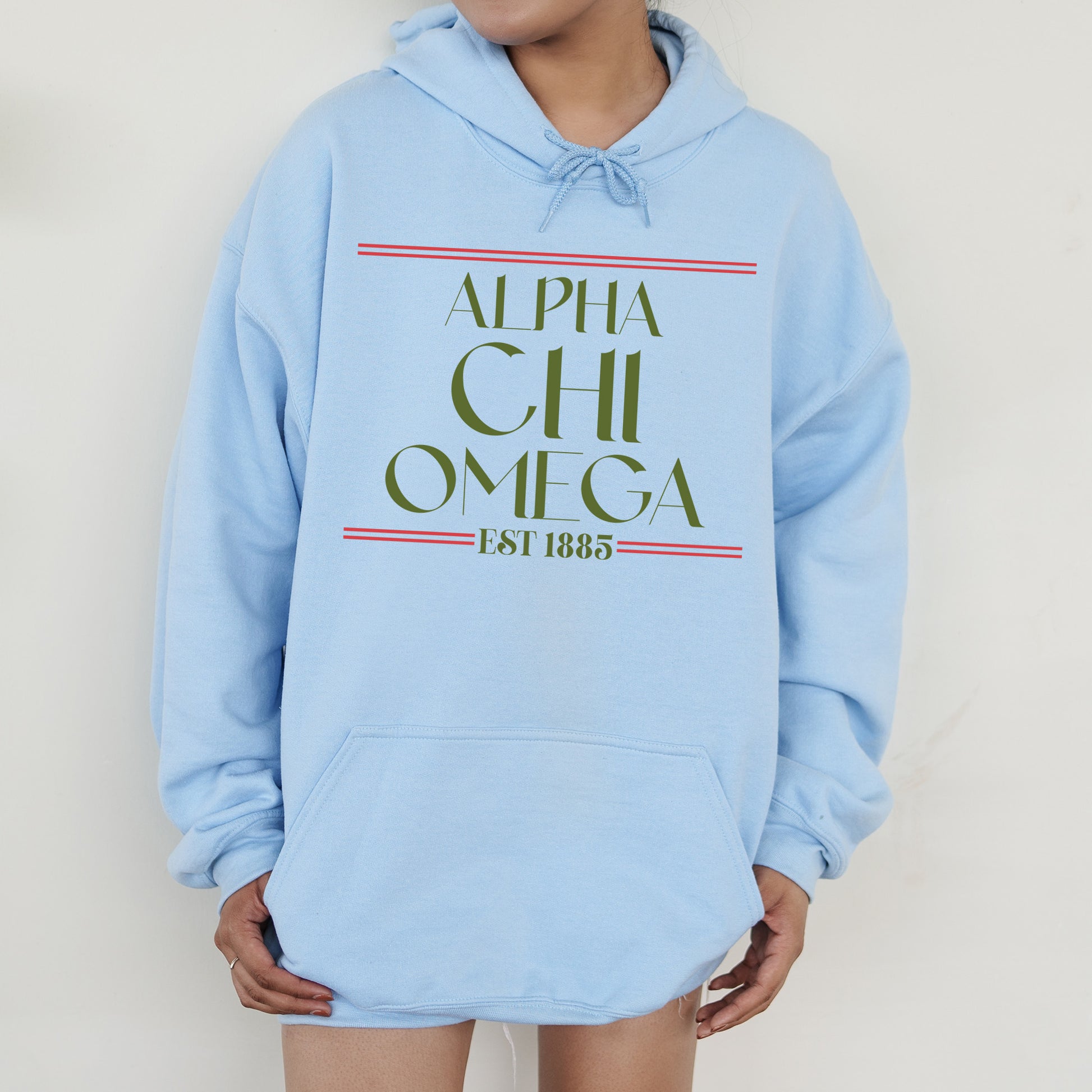 a person wearing a blue hoodie with the words alpha chi omega printed on it