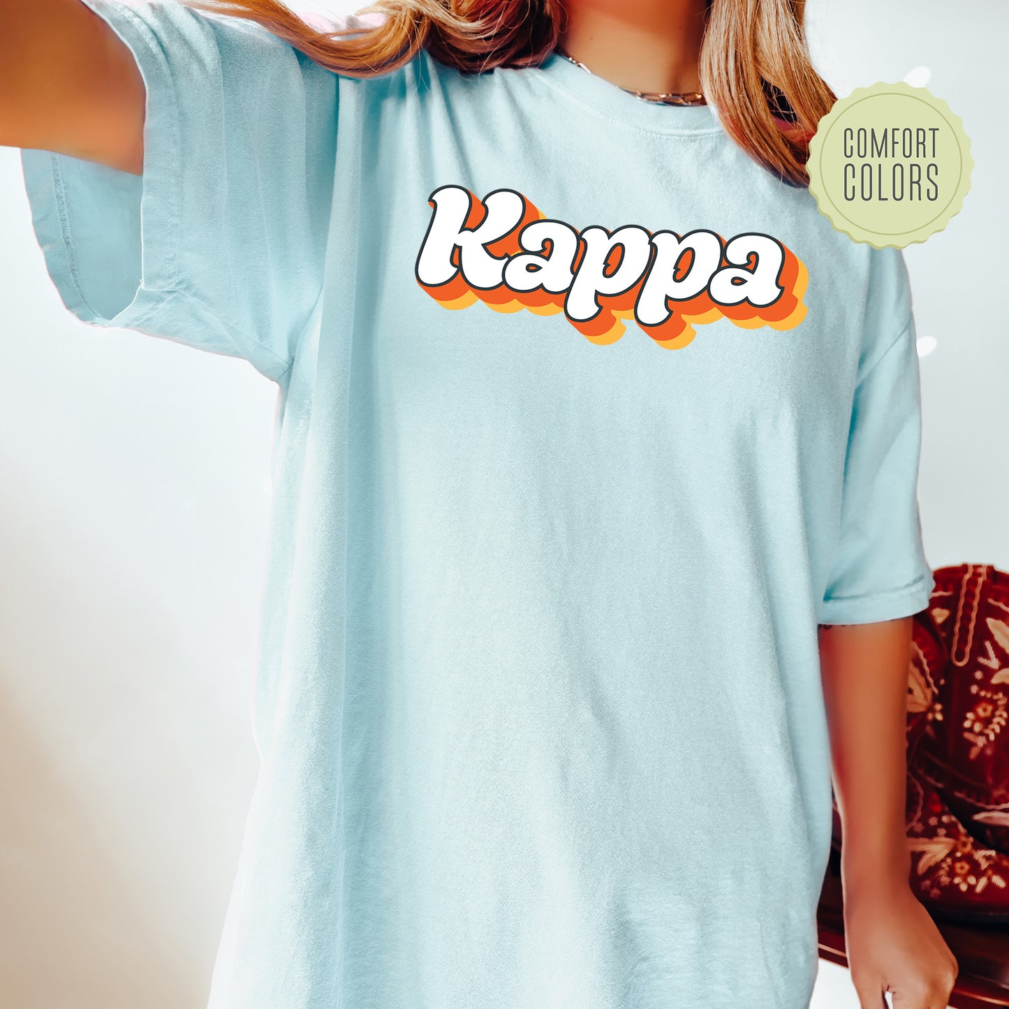 a woman wearing a light blue kappa t - shirt