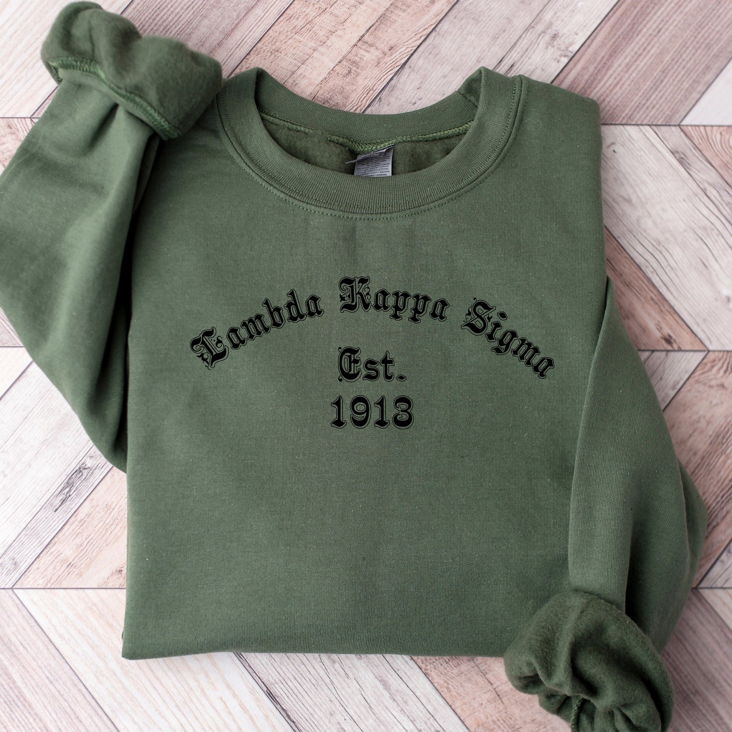 a green sweatshirt with a black embroidered name on it