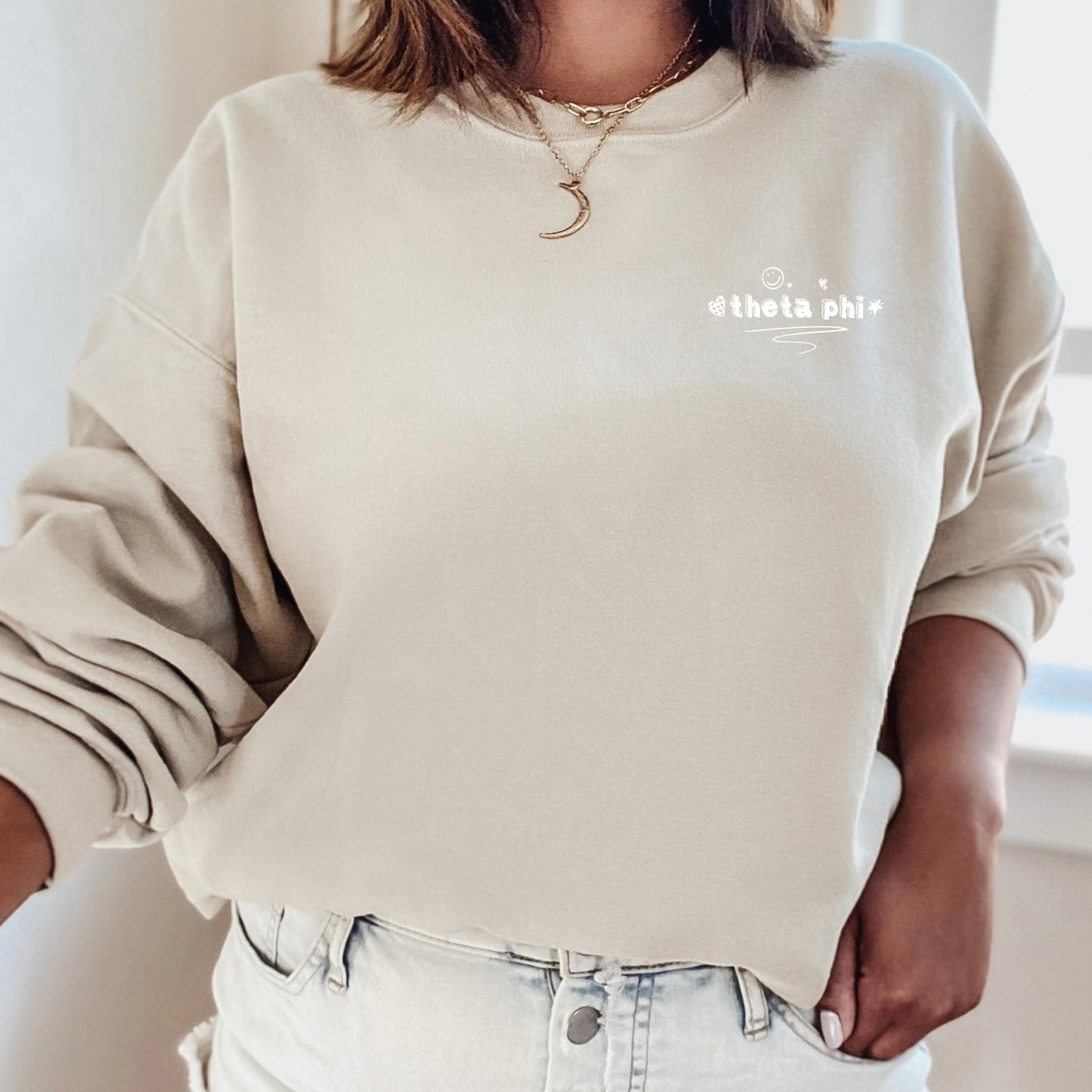 a woman wearing a white sweatshirt and jeans