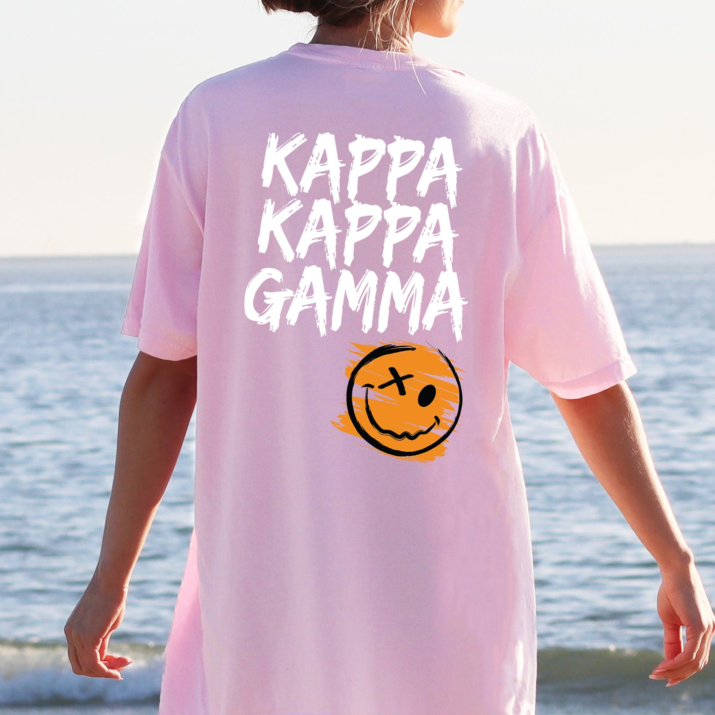 a person wearing a pink shirt with a smiley face on it