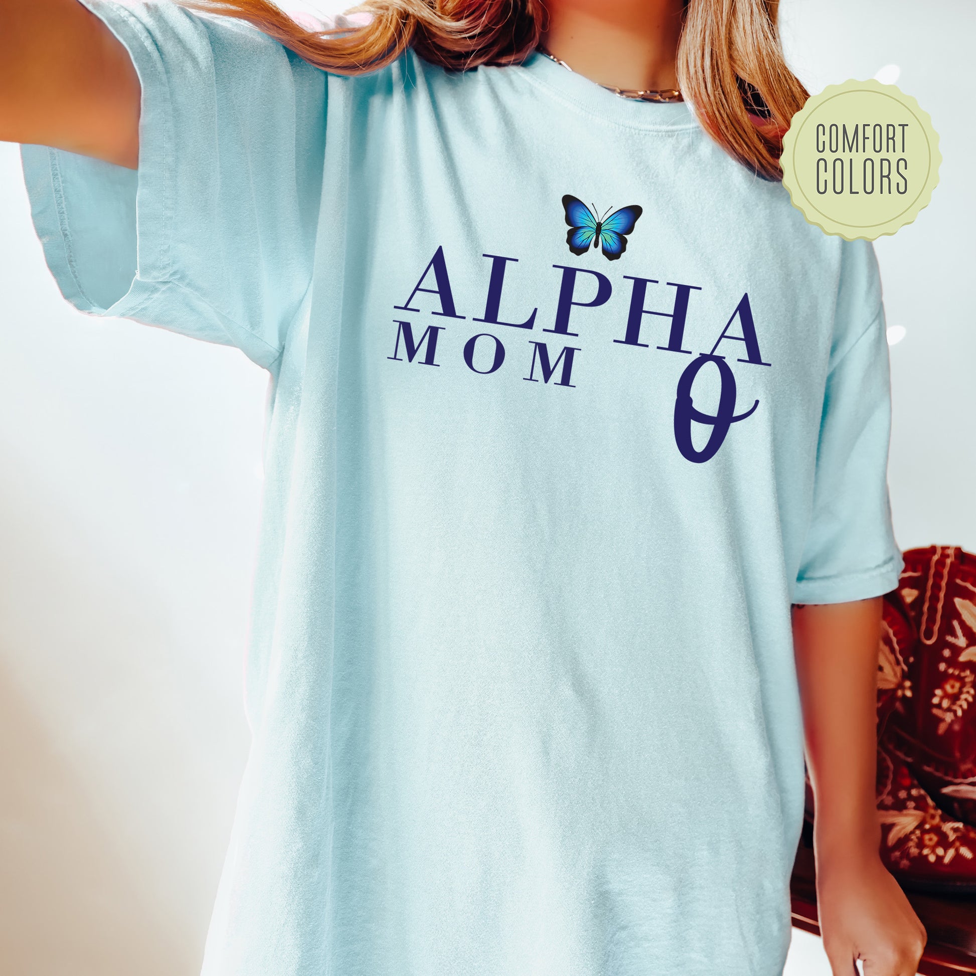 a young girl wearing a blue shirt with a butterfly on it