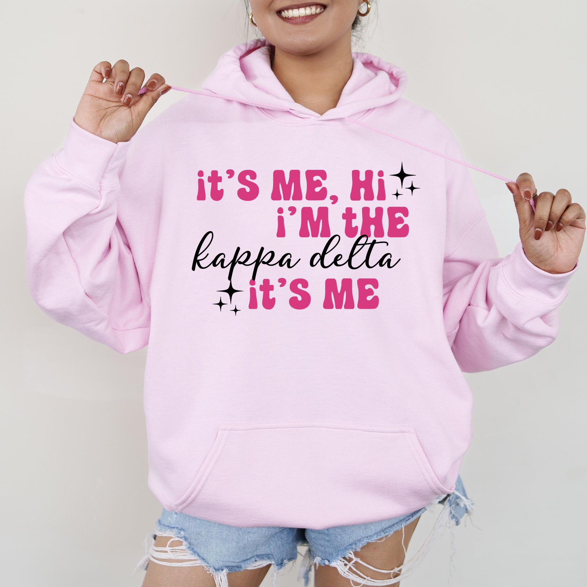 a woman wearing a pink hoodie that says it's me, i '