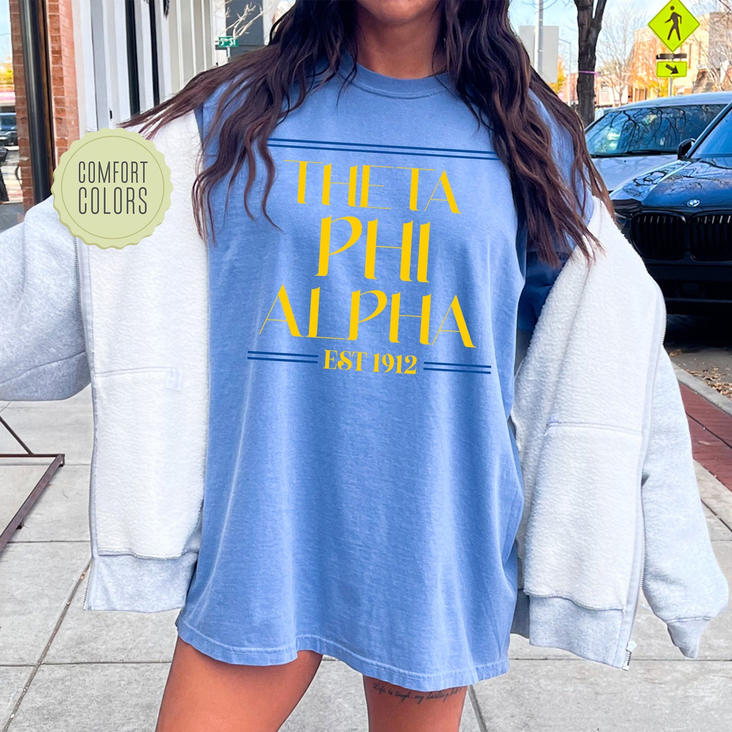 a woman is standing on the sidewalk with a blue shirt