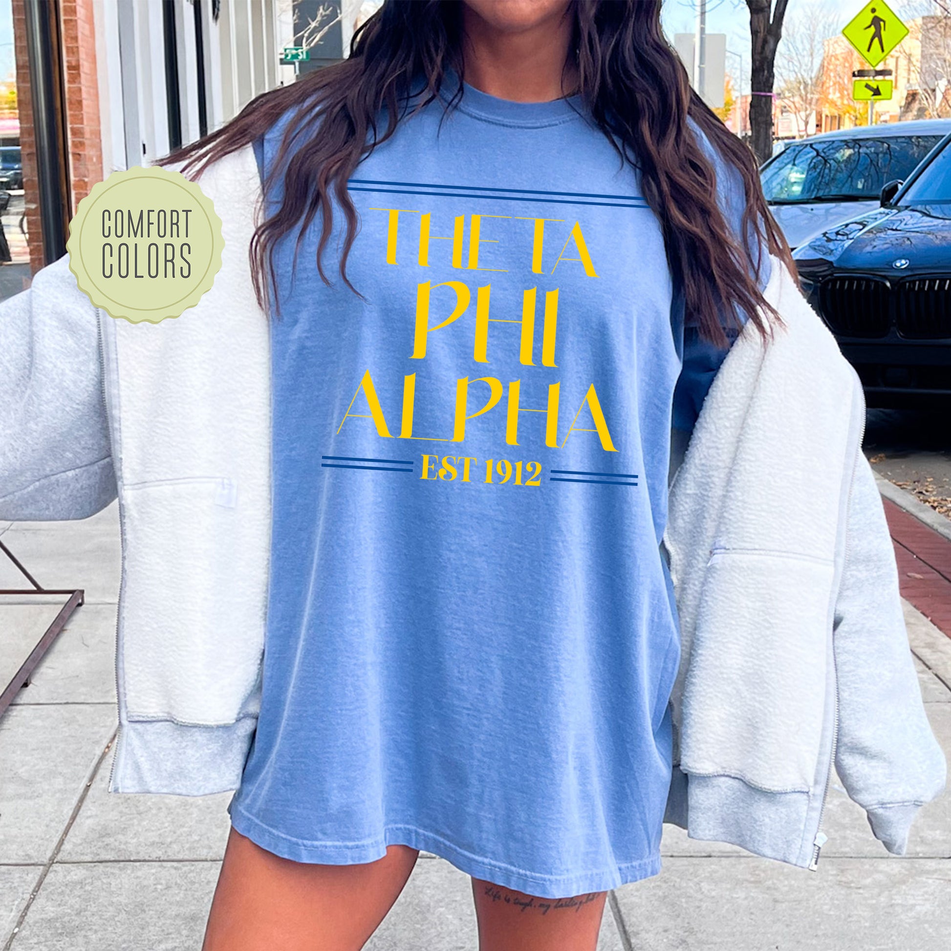 a woman is standing on the sidewalk with a blue shirt