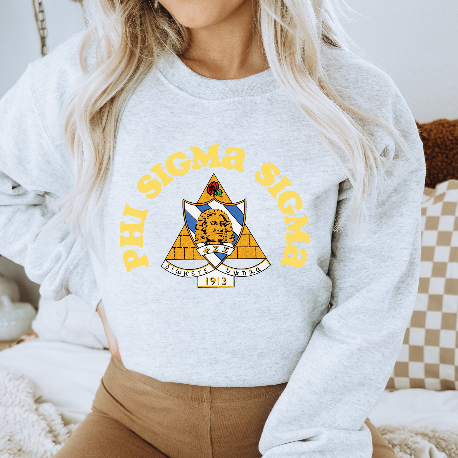 a woman wearing a grey sweatshirt with a yellow and blue logo on it