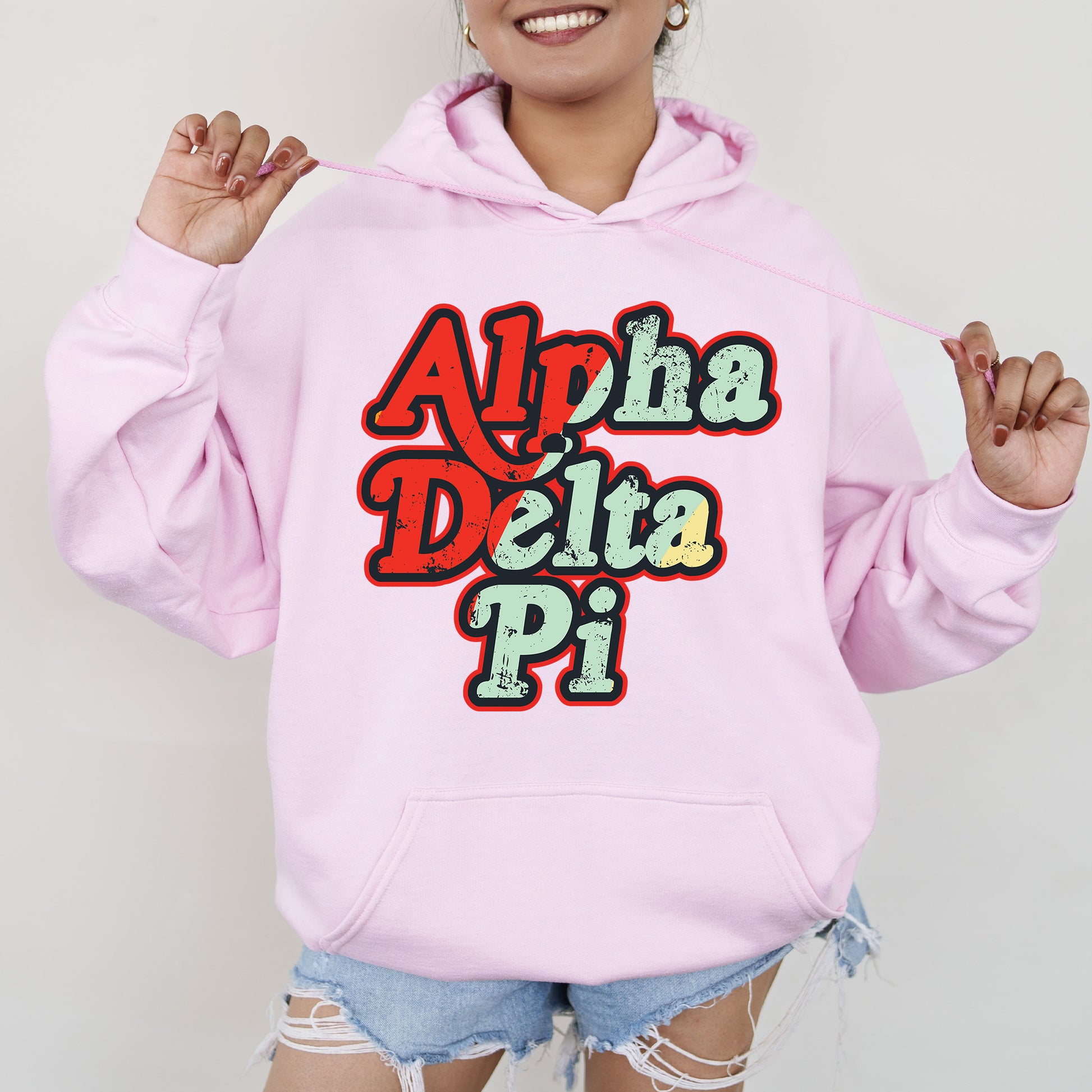a woman wearing a pink hoodie that says apha delta pi
