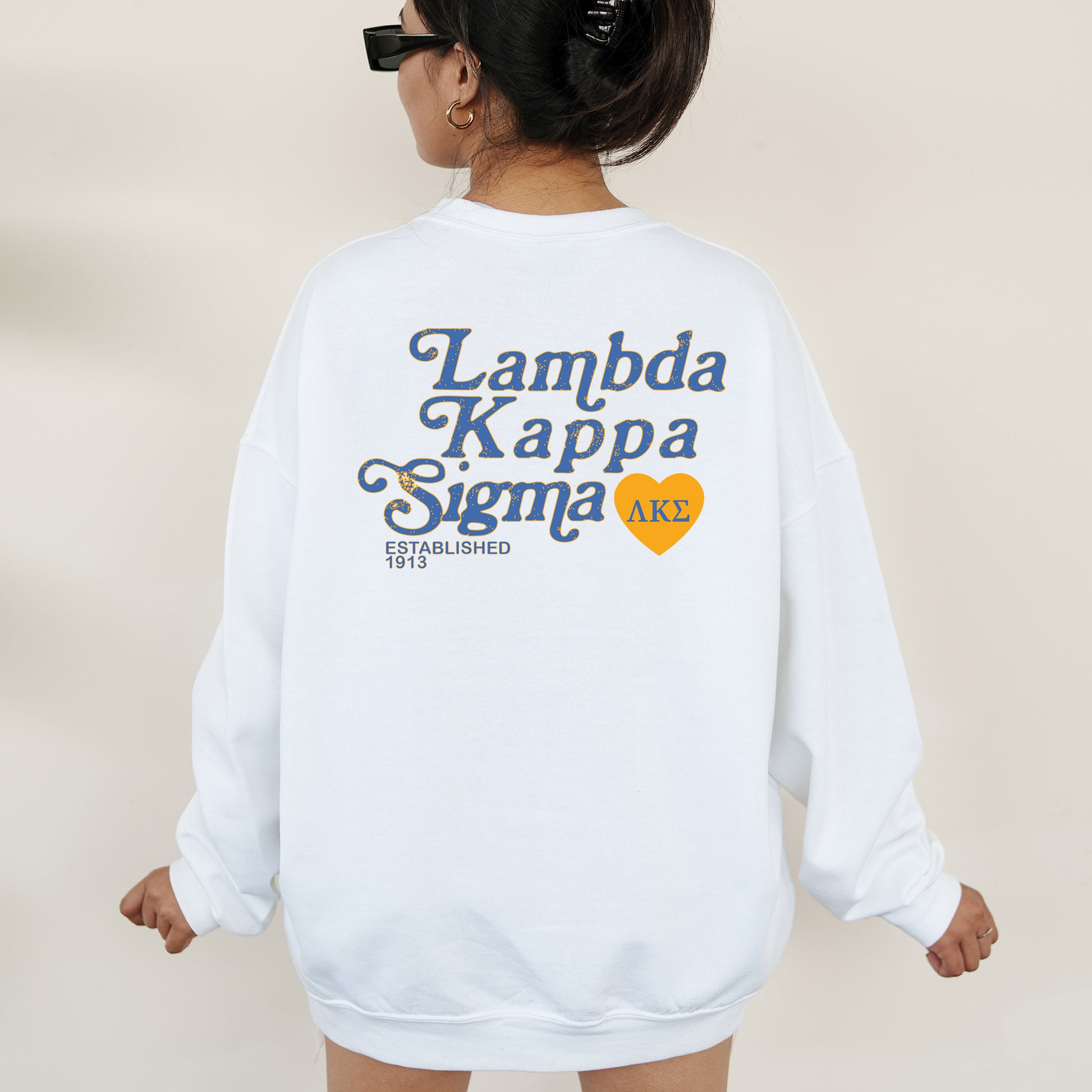a woman wearing a white sweatshirt that says i amba kappa sigm