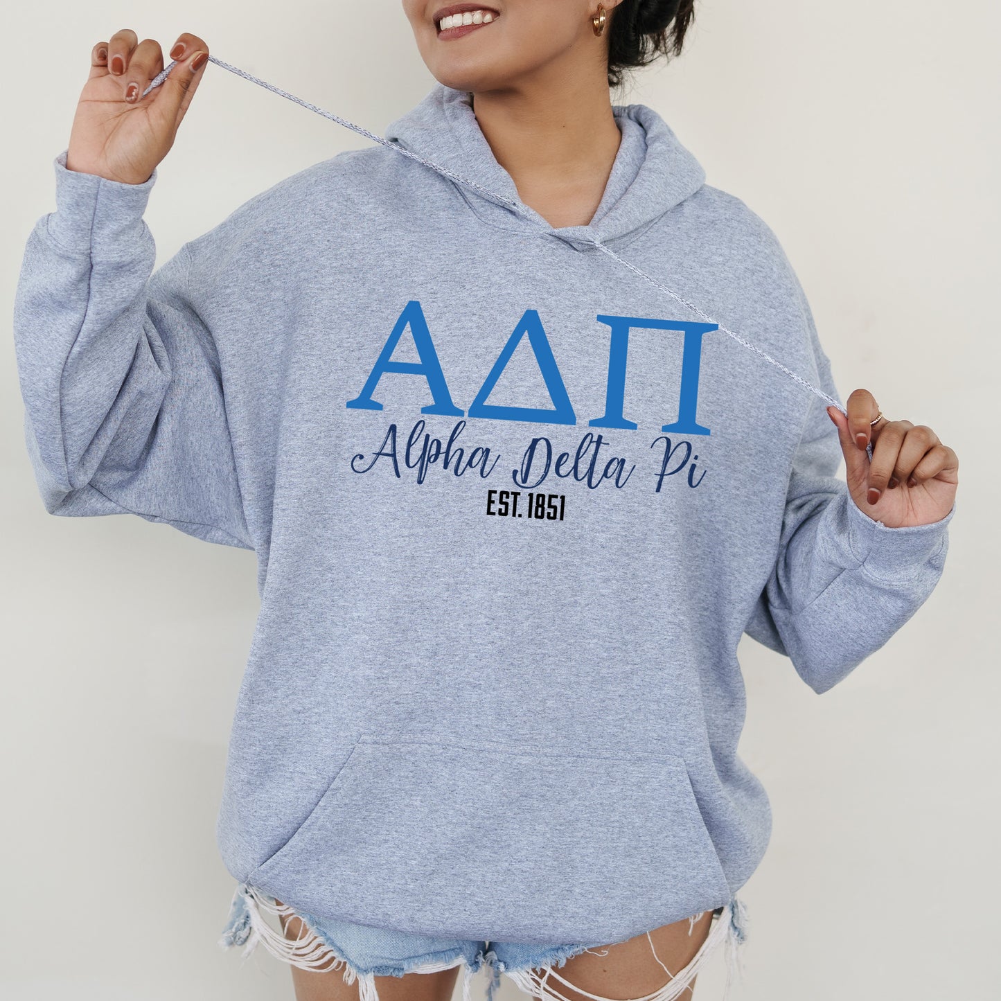 a woman in a blue hoodie holding a toothbrush