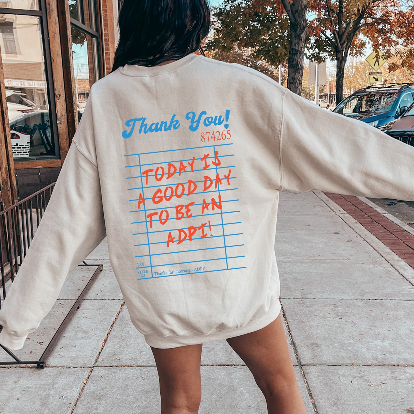 a woman is walking down the sidewalk with her back to the camera
