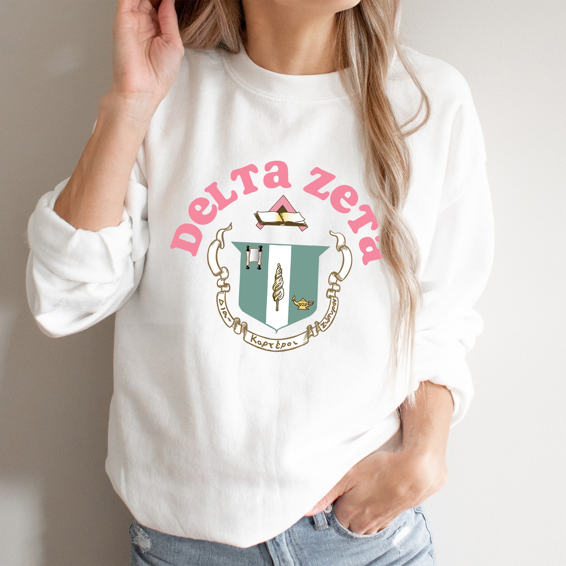 a woman wearing a white sweatshirt with a crest on it