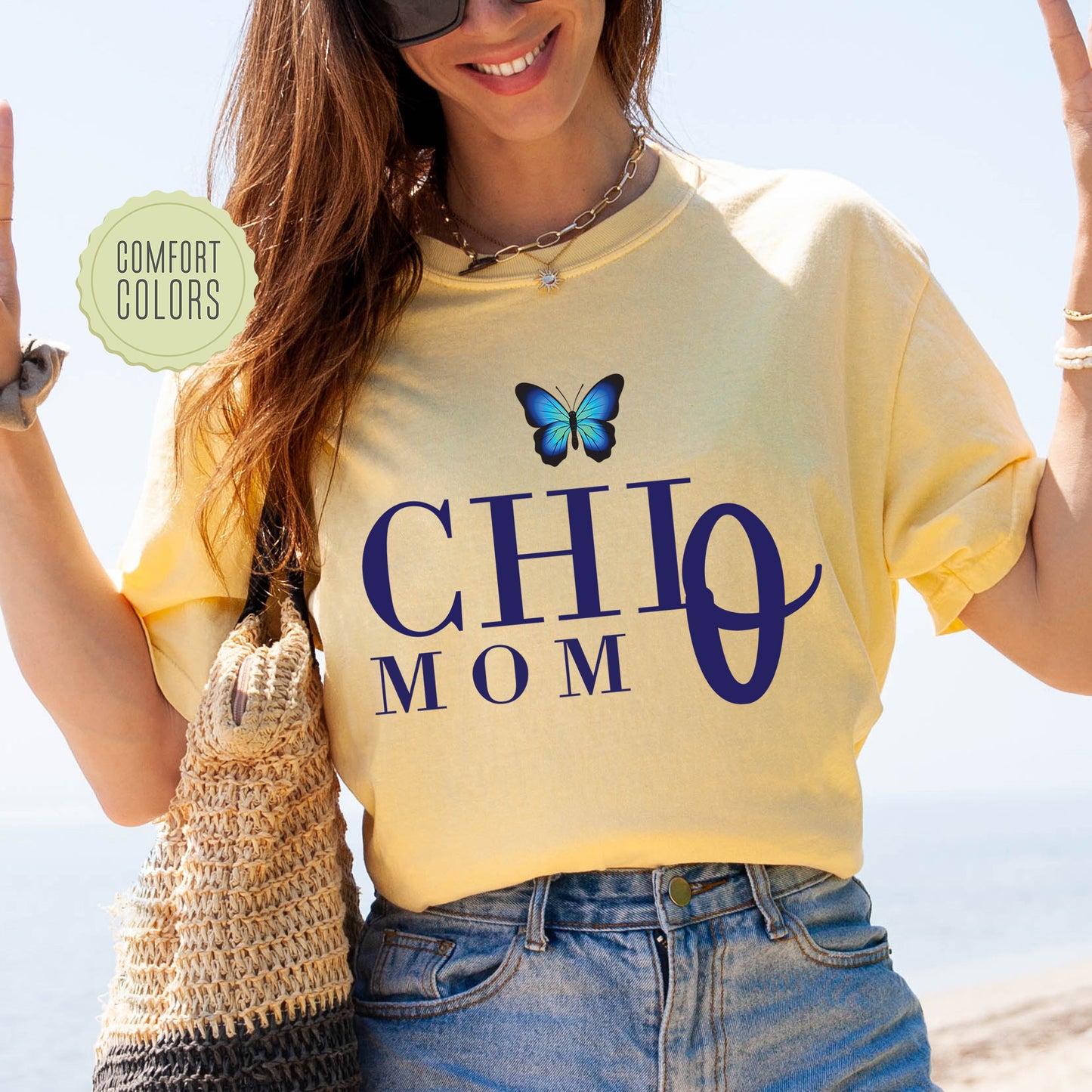 a woman wearing a shirt that says chio mom with a butterfly on it