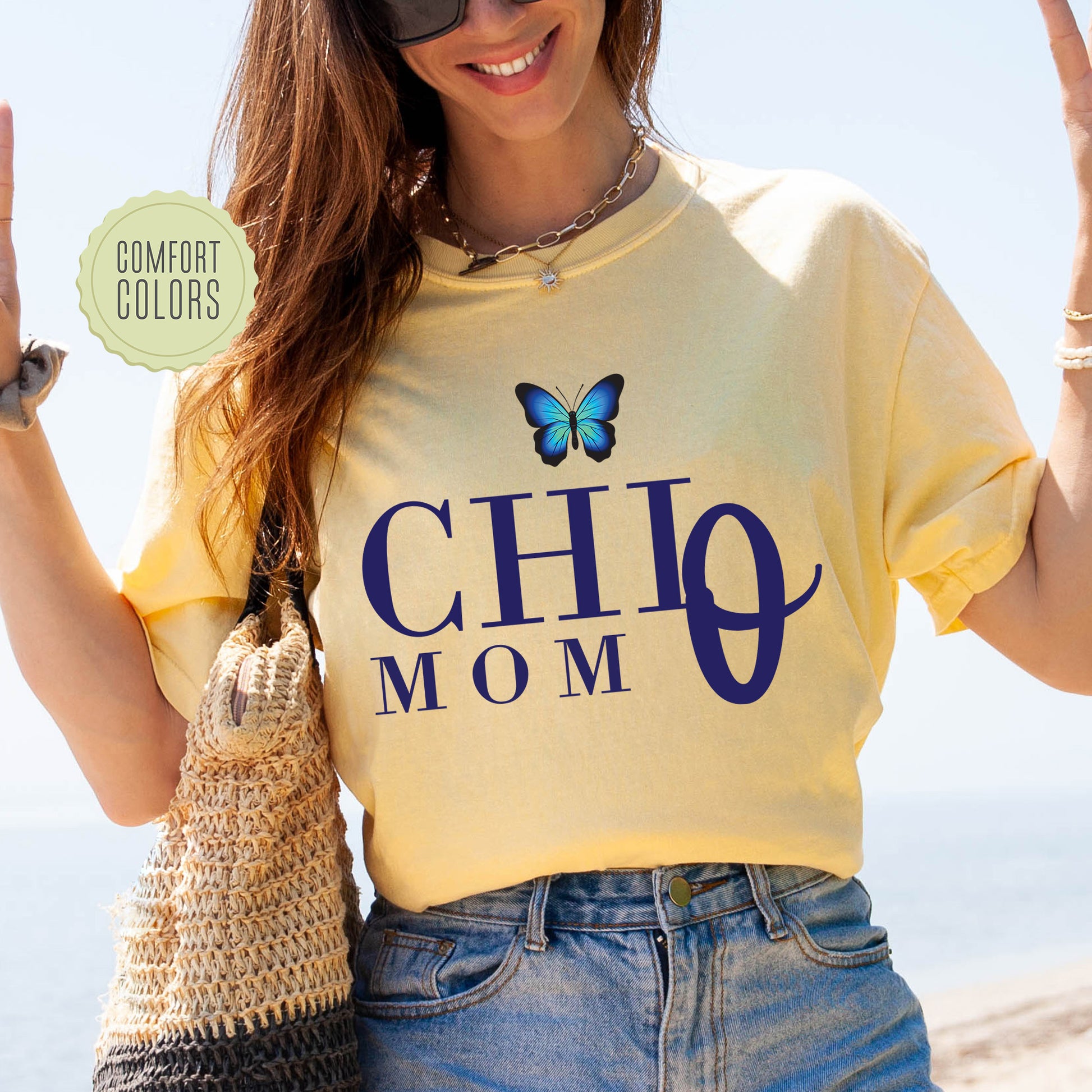 a woman wearing a shirt that says chio mom with a butterfly on it