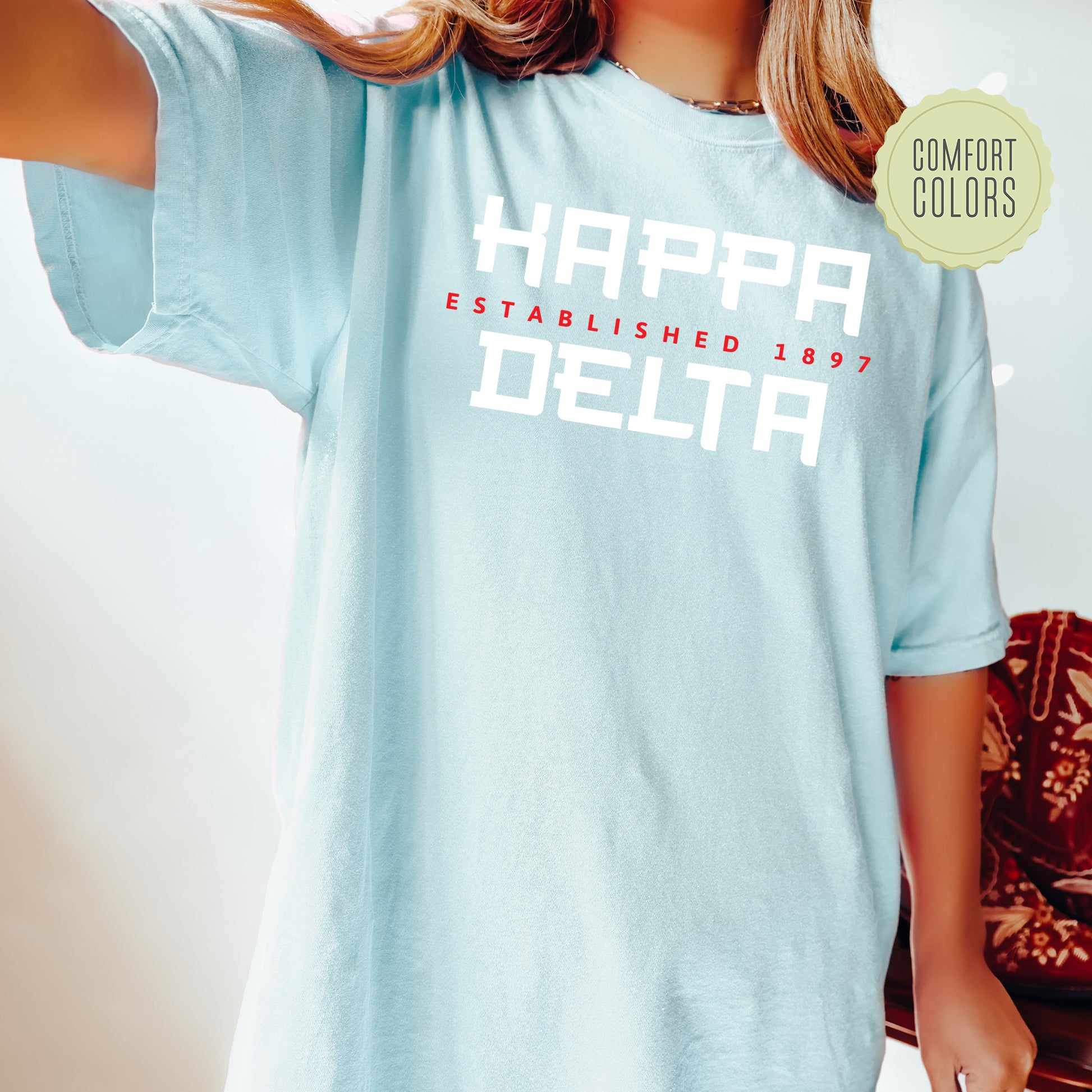 a woman wearing a blue t - shirt that says happy established baby delta