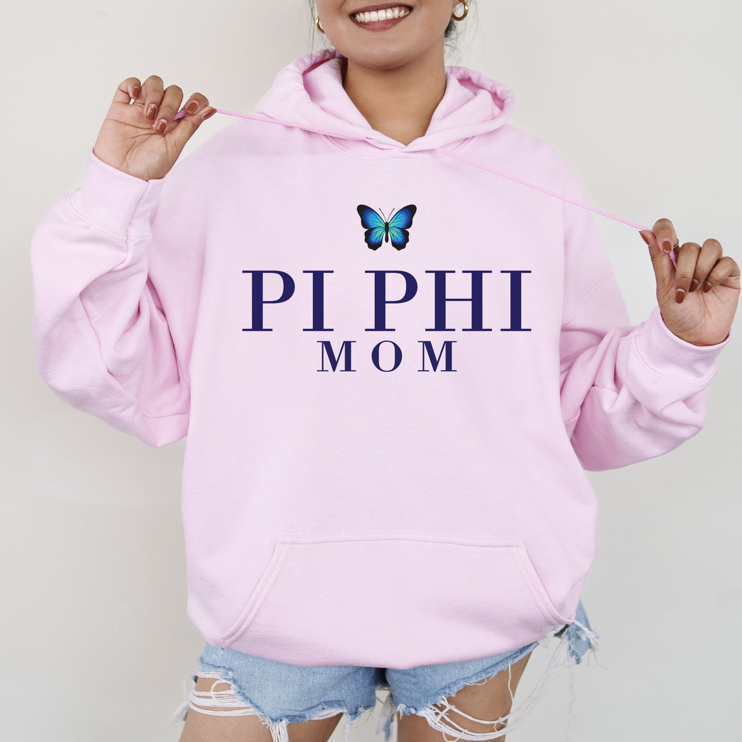 a woman wearing a pink hoodie with a butterfly on it
