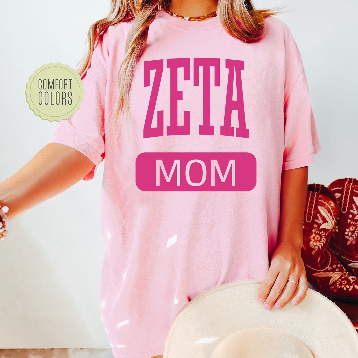 a woman wearing a pink shirt that says zeta mom