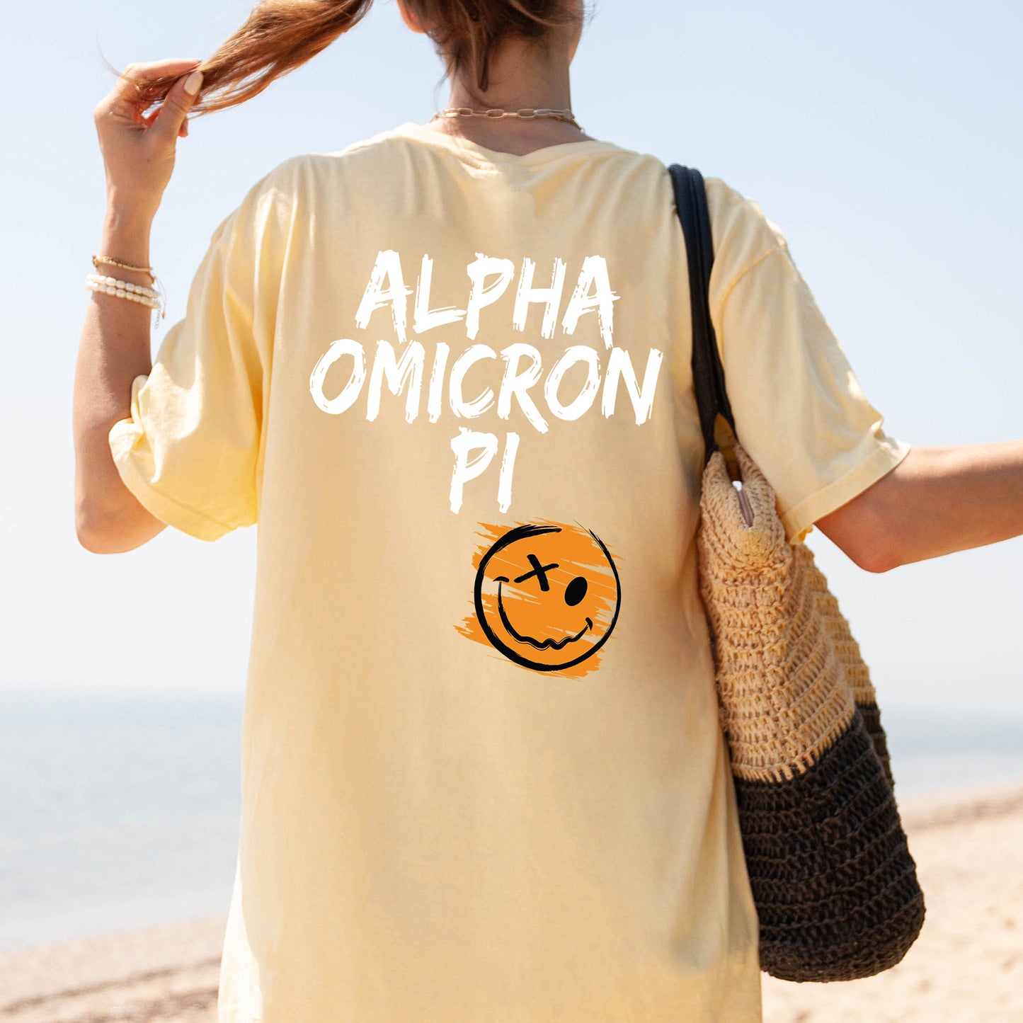 a woman is walking on the beach with a smile on her shirt