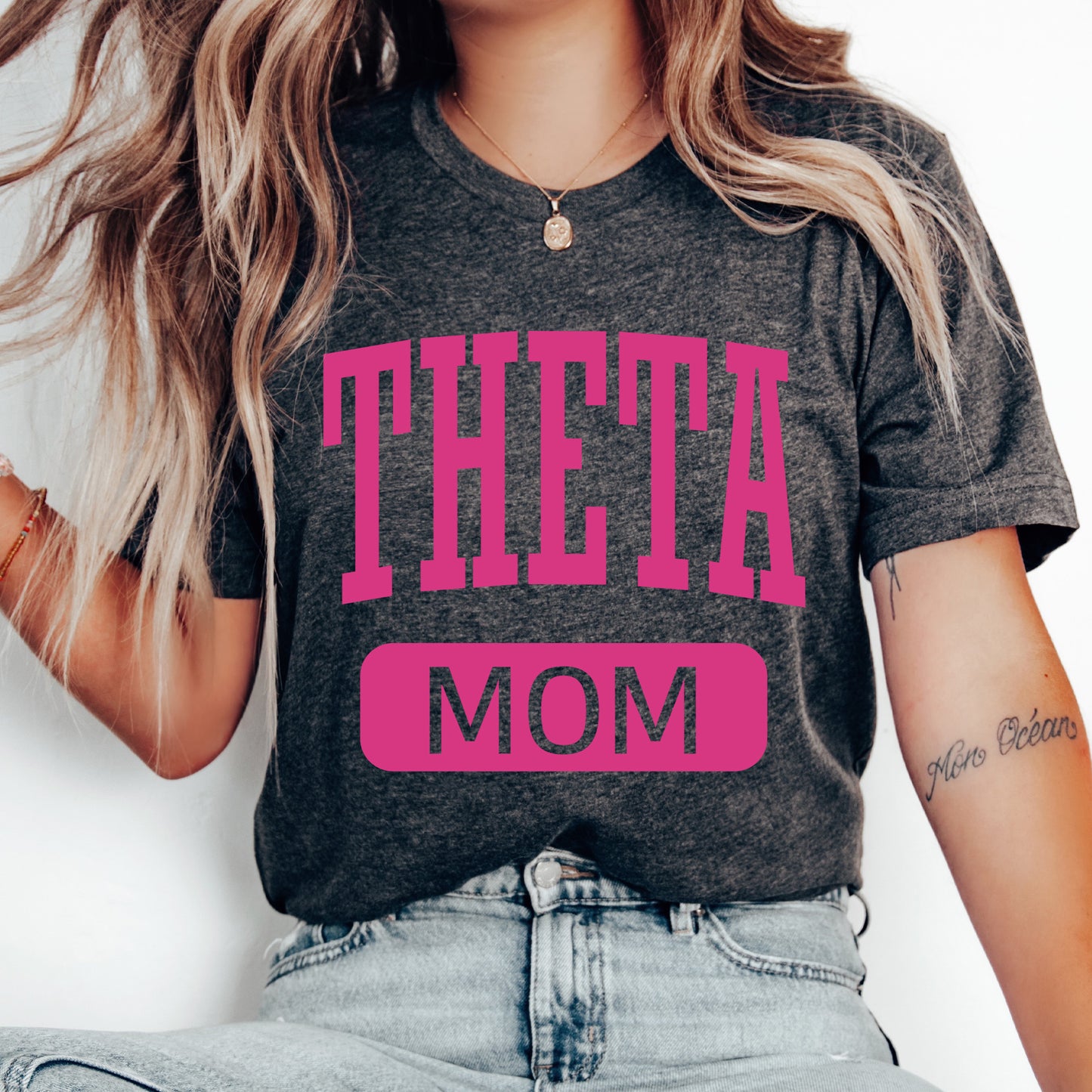 a woman wearing a t - shirt that says,'theta mom '
